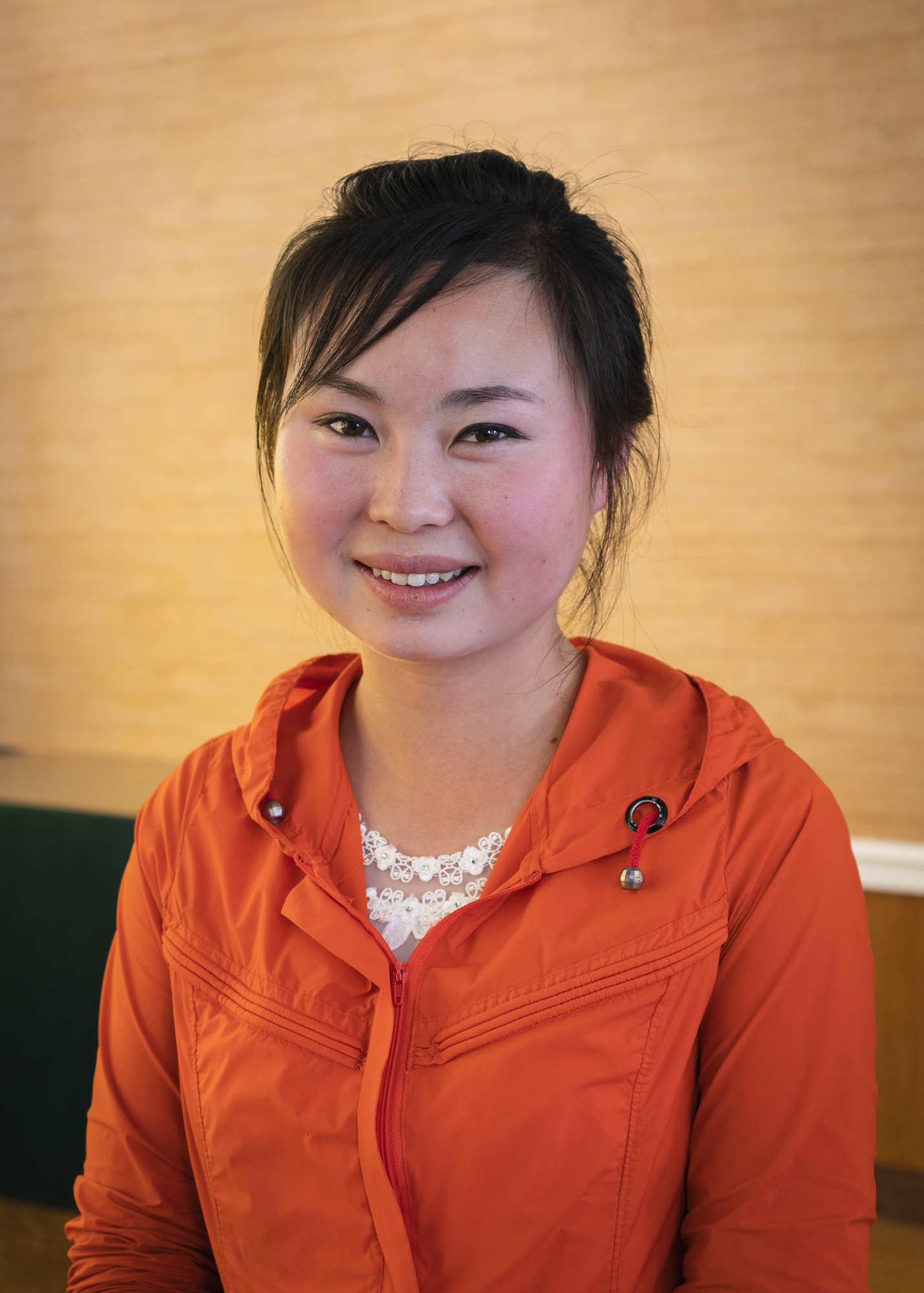 Portrait of a young woman working at the Songdowon International Children’s Camp. At first afraid to be caught interacting with a foreigner by the omnipresent minders, she agreed to be photographed after hiding herself behind a column in one of the