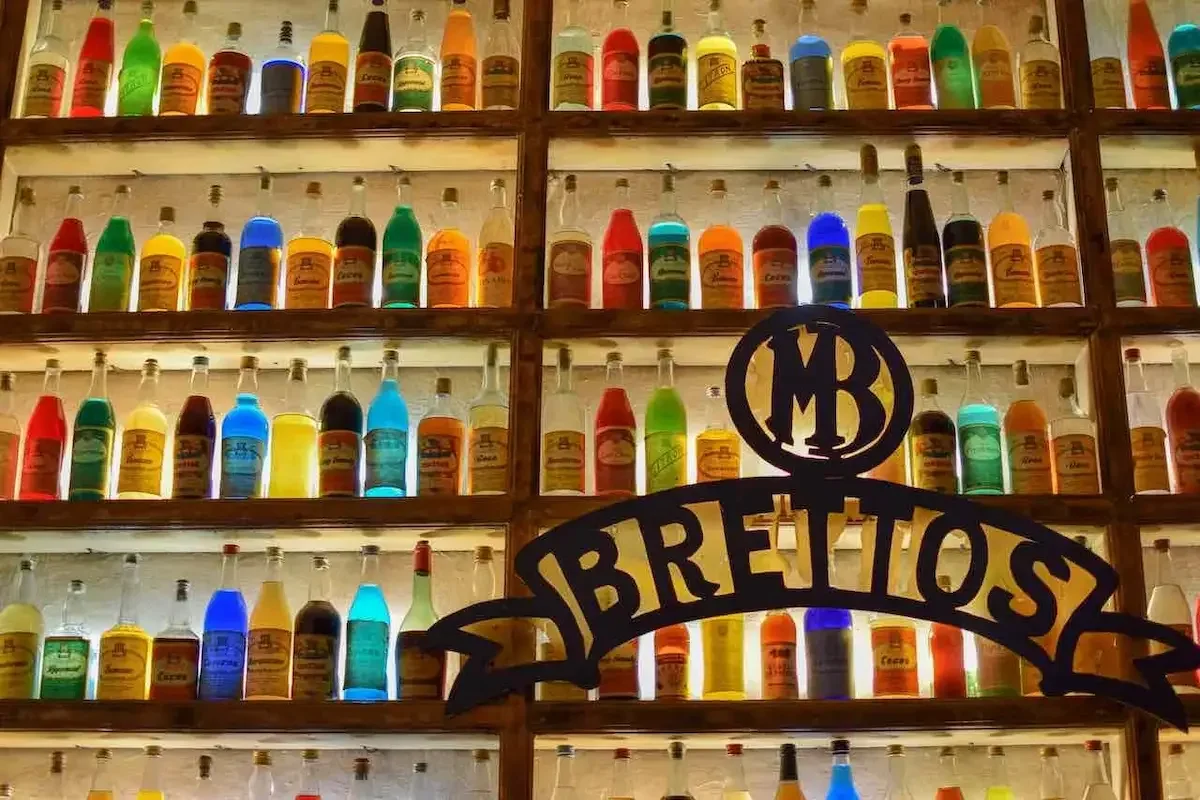 Backlit bottles of colourful liqueur lining the walls of Brettos bar in Athens