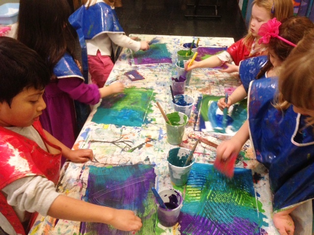Children painting at a table together.
