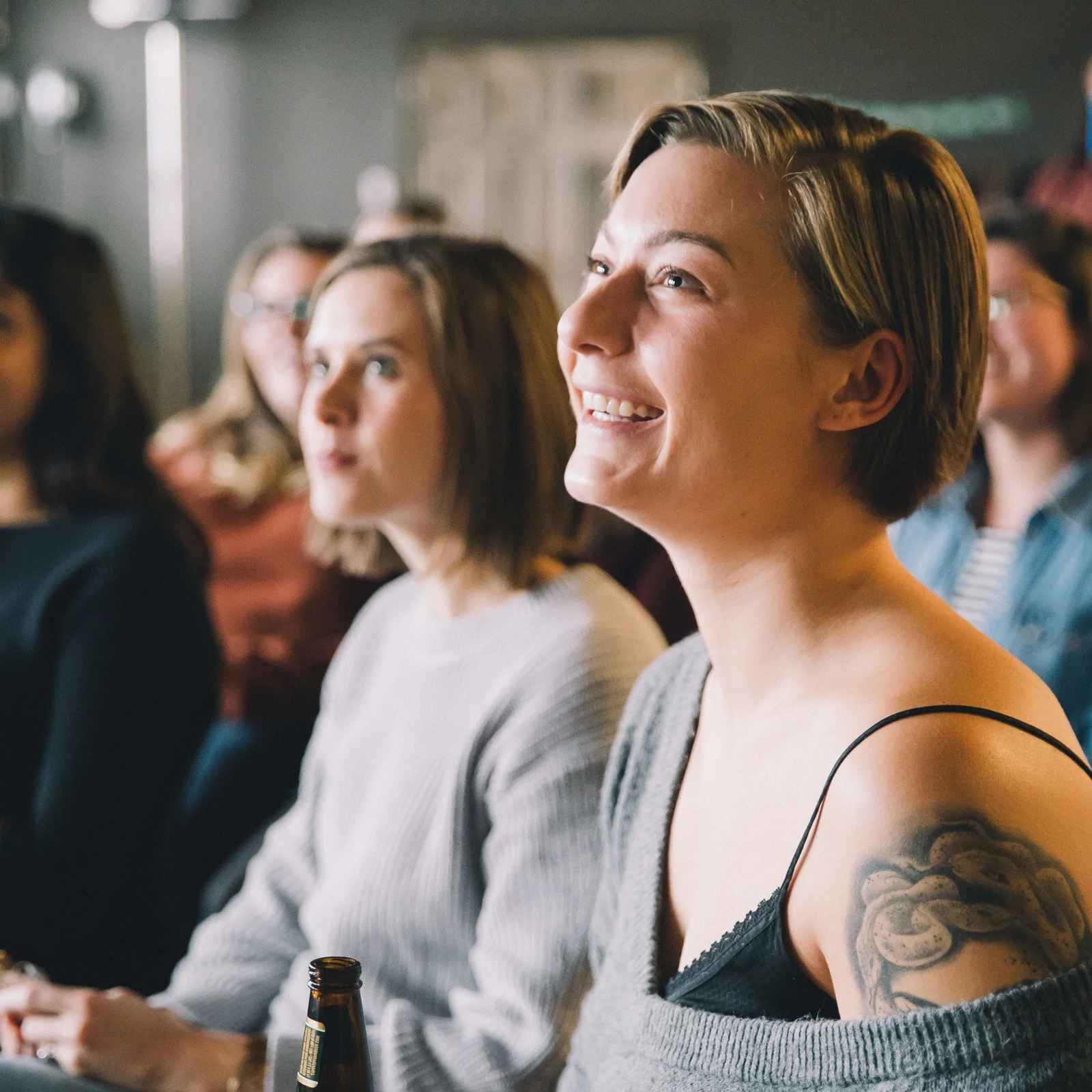 Woman smiling while sitting in audience at a Syzygy women's event.jpg