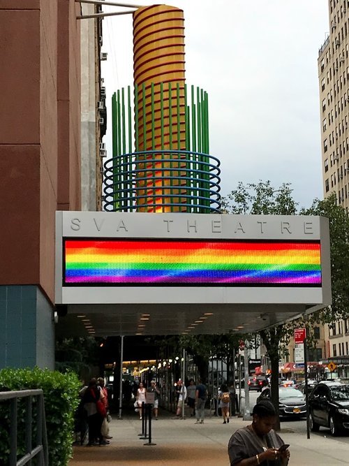 Image: A digital LGBTQ+ Pride rainbow banner outside the SVA Theater in New York City