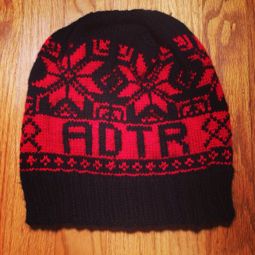 Black and red knit beanie with snowflake and geometric patterns, and the word 'AOTR' displayed in the center.