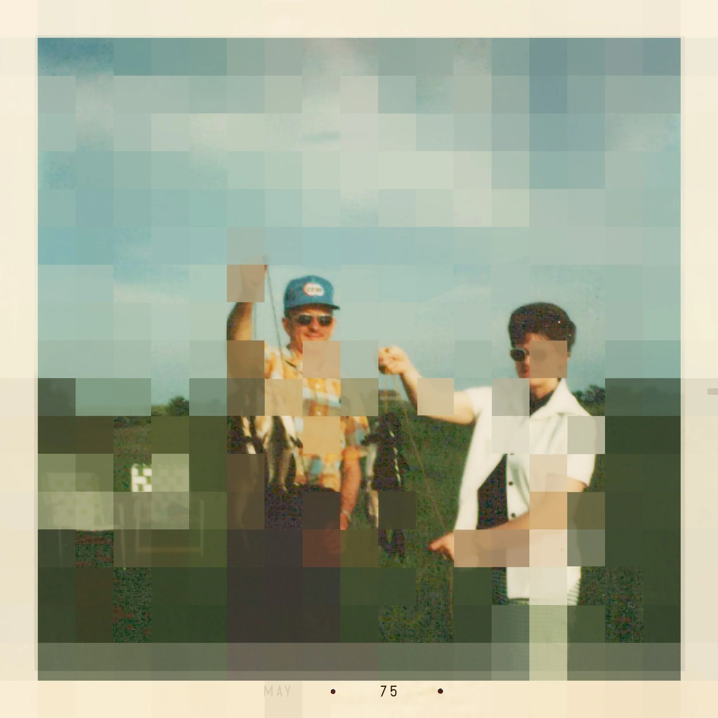 Two men standing outdoors, one wearing sunglasses and a cap, raising his hand, and a woman in a patterned dress. The background shows a clear sky and some greenery.
