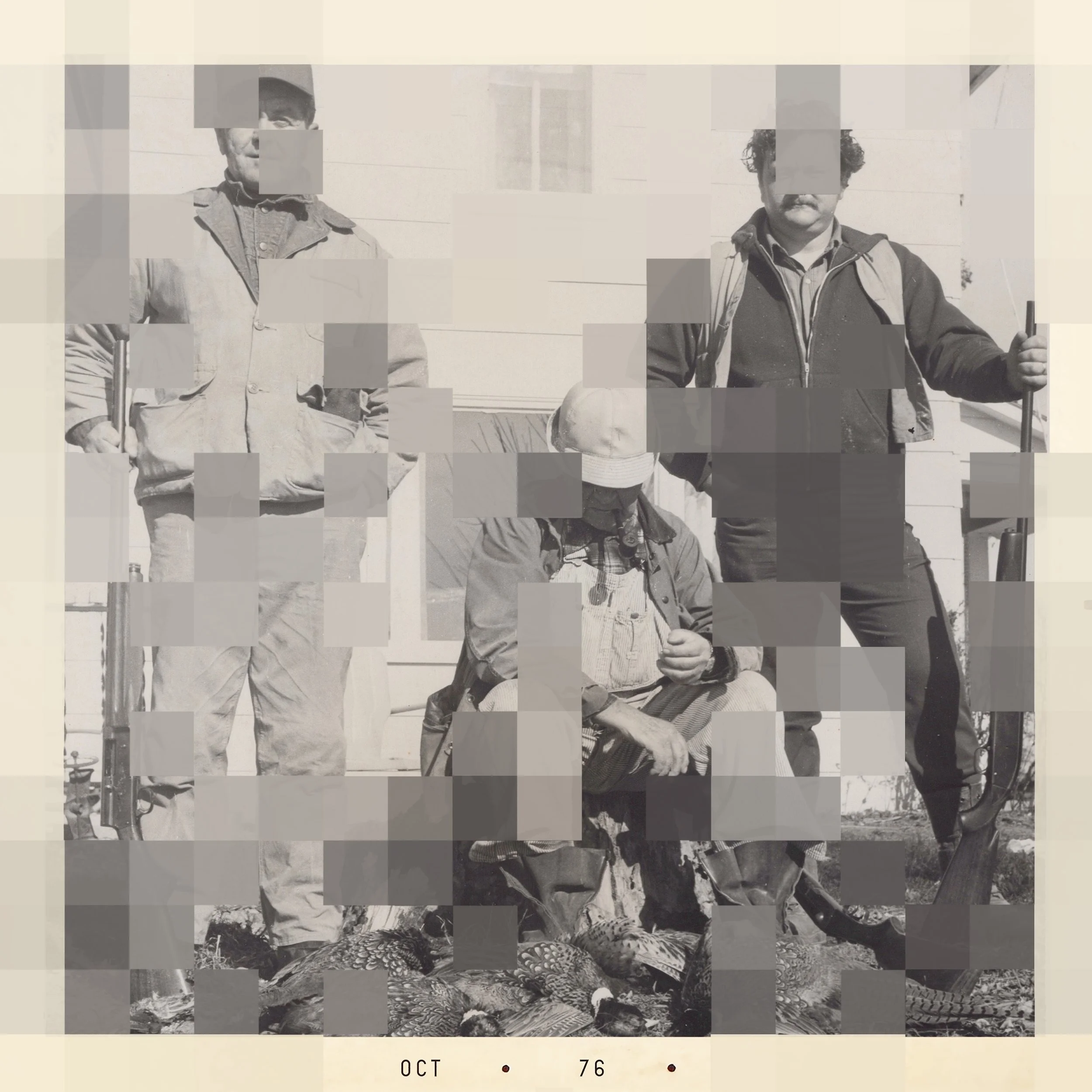 Black and white photo of two men standing outdoors. The man on the left is wearing a cap, glasses, and a jacket, holding a cane. The man on the right has curly hair, a mustache, and is dressed in a jacket over a shirt, holding a walking stick. The ba