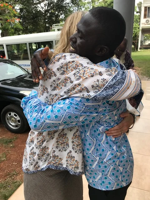 The Rev. Father Theo Odametey and the Rev. Canon Dr. Sharon Hiers greet one another.