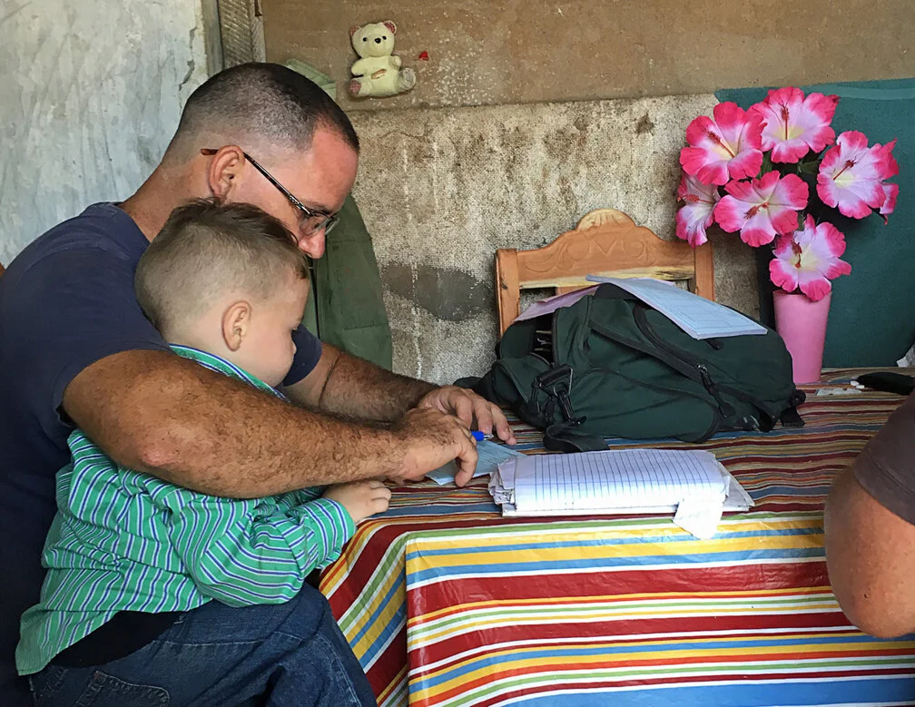 Father Juan Carlos with his son Jesus Alejandro examining records at the farm