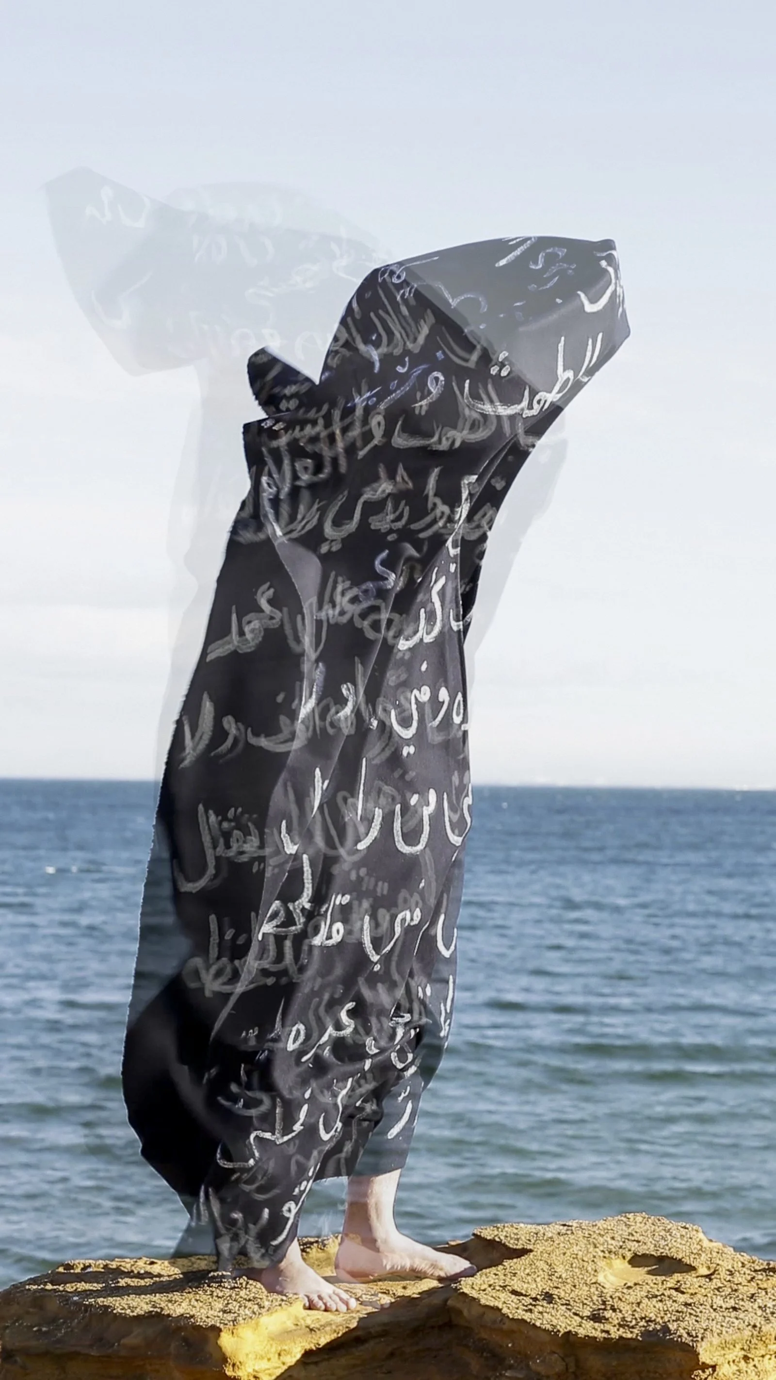   The Black Shroud, one channel video, 3 min and 27 Sec,2022   In some Islamic cultures, a black shroud inscribed with Quranic verses symbolizes mourning, honours the deceased, and invokes spiritual protection and mercy. In this self-portrait, the bl