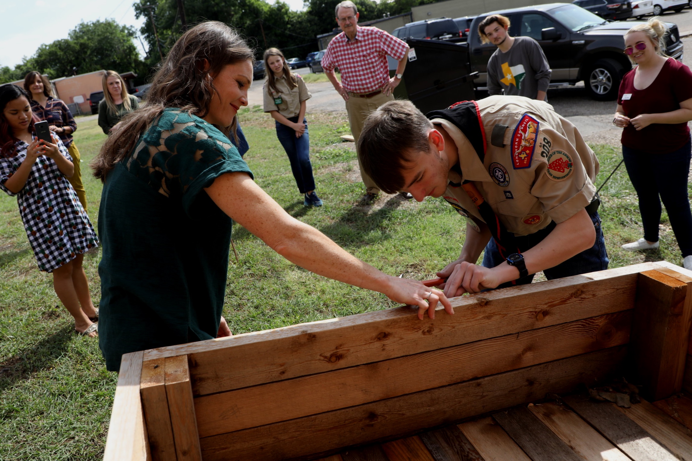 Kelly Atkinson and Carter Rogers nail a plaque to the garden bed, honoring Carter’s Eagle Scout project totaling 139 hours of service for The Cove.