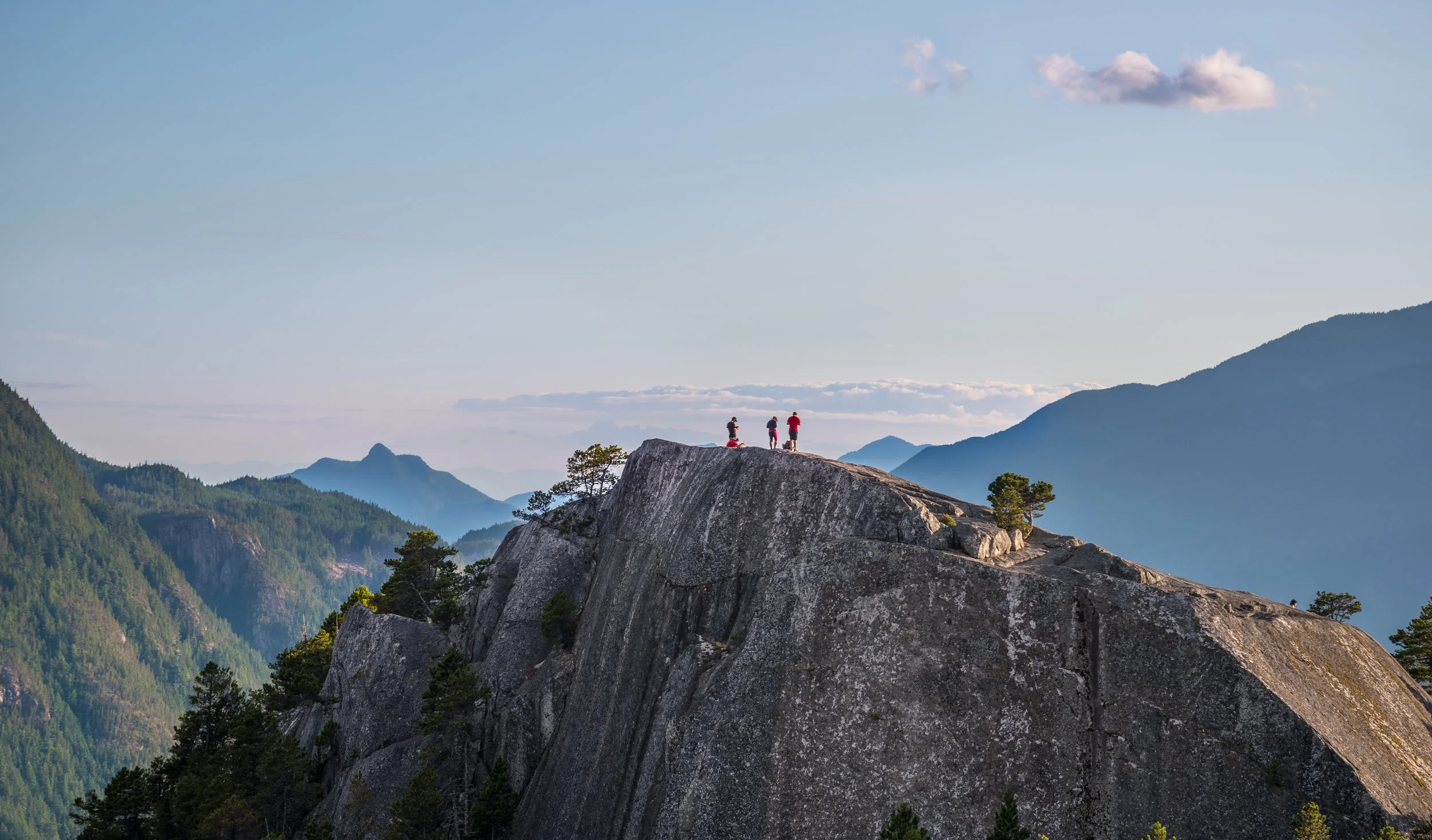 Hiker reaching the summit of a rocky peak