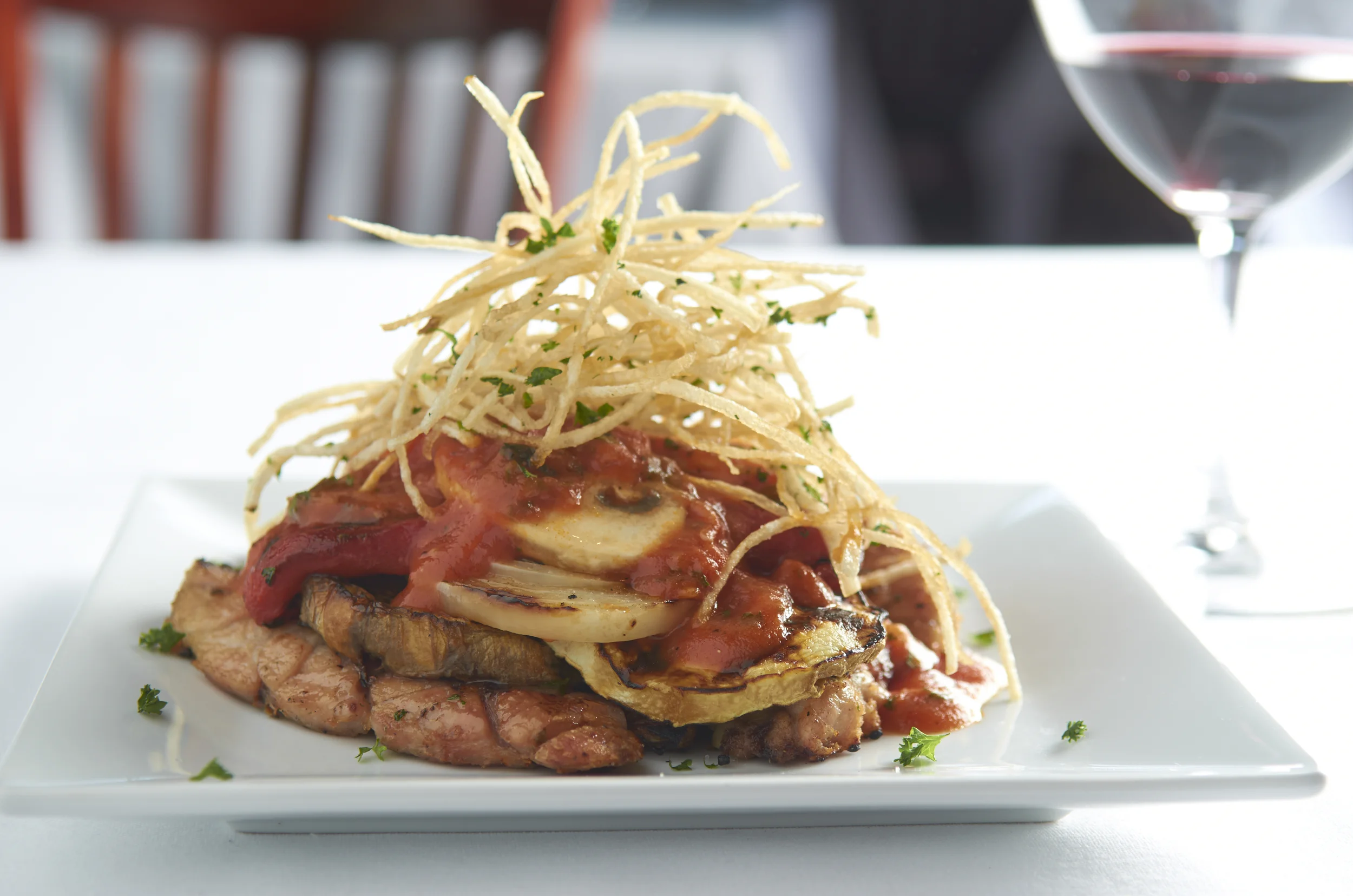Mollejas De La Plata. Grilled Veal Sweetbreads, Grilled Eggplant, Roasted Red Bell and White Onions, in Roma Tomato with Crispy Potato Shavings.