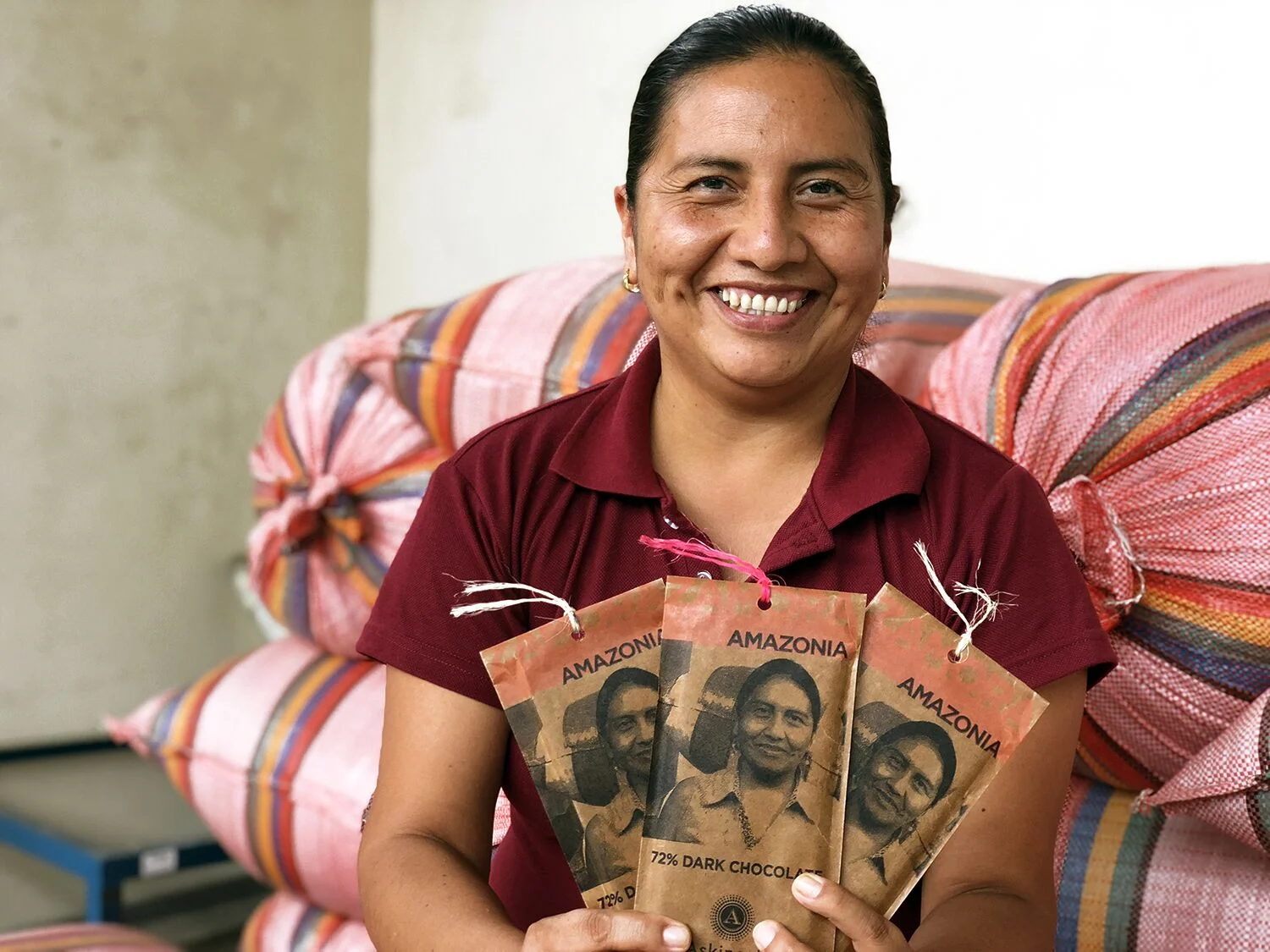 Cocoa farmer Monica Guaman holding (and featured on) the 72% Zamora, Amazonia dark chocolate bar by Askinosie. Photo credit: Askinosie Chocolate