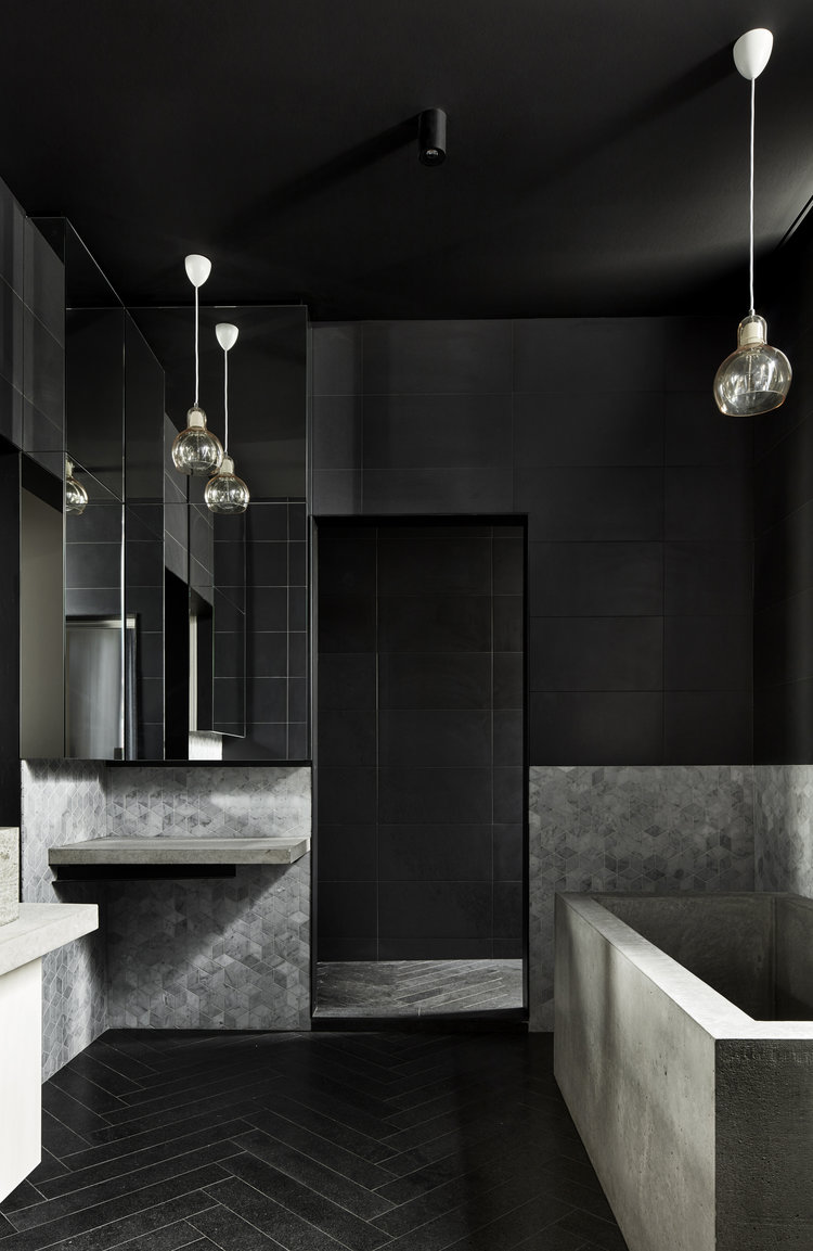 Black bathroom ceiling, floor tiles and black wall tiles contrasted against grey wall tiles in black and gray bathroom.
