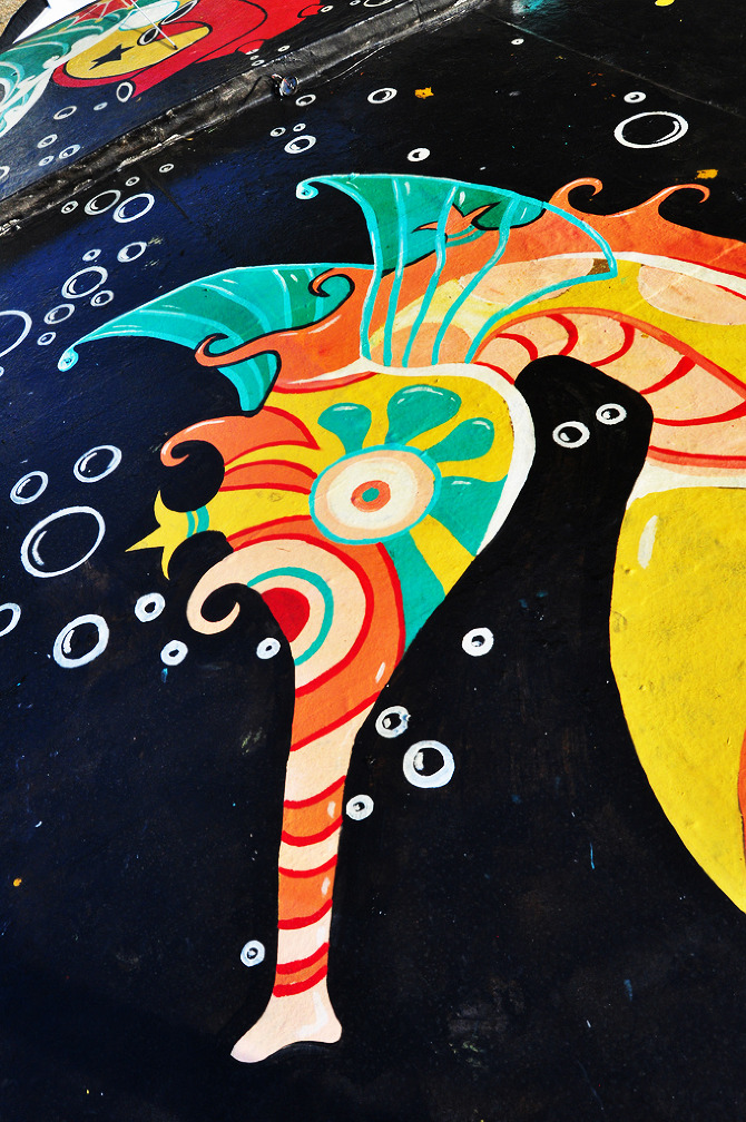   Detail of Seahorse mural by Maxine Nienow    In 2012, Maxine co-created  FlutuArte , a public art installation where 45 international artists joined to paint murals on the rooftops of 60 fishing boats in a historic harbor in Rio de Janeiro, Brazil.