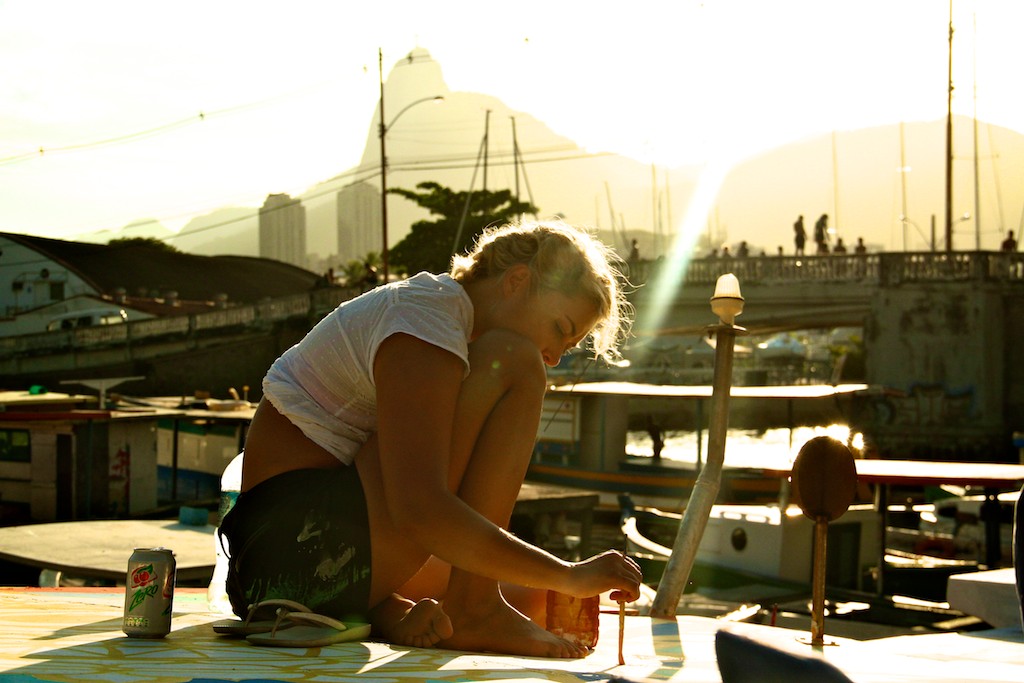   Maxine Painting a mural on a boat rooftop    In 2012, Maxine co-created  FlutuArte , a public art installation where 45 international artists joined to paint murals on the rooftops of 60 fishing boats in a historic harbor in Rio de Janeiro, Brazil.