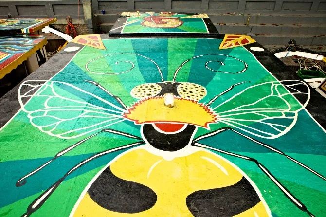 Detail of Bee mural by Maxine Nienow. Heart by Nicolina In 2012, Maxine co-created FlutuArte , a public art installation where 45 international artists joined to paint murals on the rooftops of 60 fishing boats in a historic harbor in Rio de Janeiro, Brazil. FlutuArte brought not only new vibrant colors to this fishing community, but also a new economy of tourism.