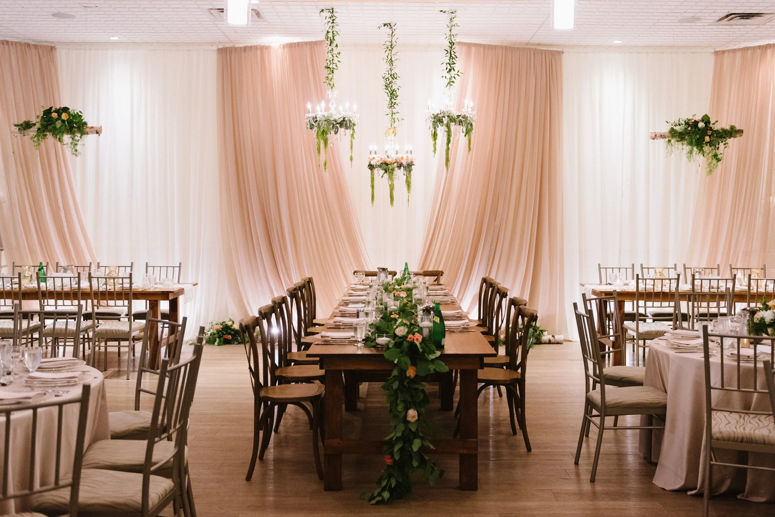 The St. Marys Ballroom, styled with harvest tables, vineyard chairs and loose greenery for the rustic chic Staffen wedding. Decor & Styling: Above & Beyond Event Design. Floral Design: Lyric Flowers. Photography: Erin Leydon.