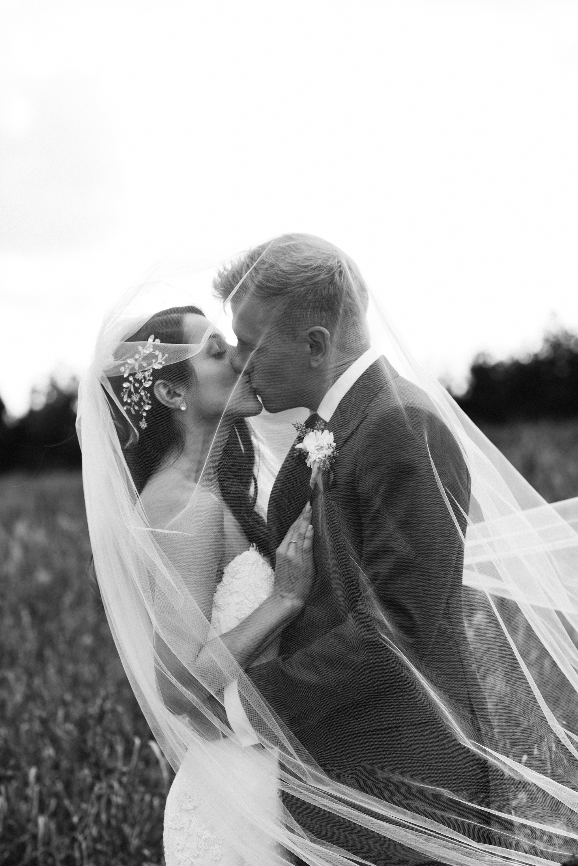 bride-groom-kissing-veil-black-white-photo