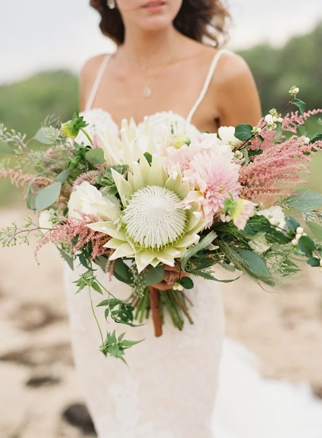 White king protea mixed with feminine dahlias and roses is a unique bridal bouquet arrangement. Photo Source: Brides .