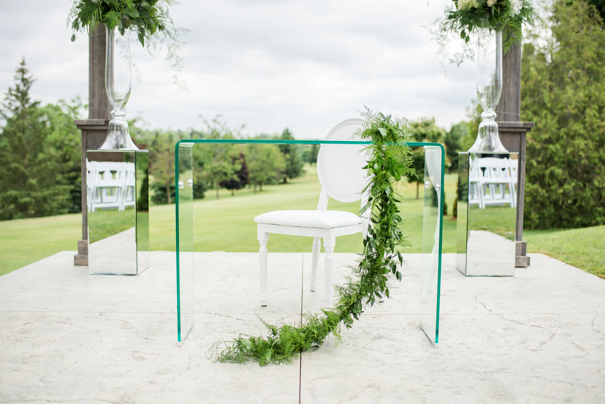 The look of translucence is one of our favourite trends of the 2018 season, so we chose to accent the ceremony setting with an acrylic ghost signing table, glass urn flower arrangements raised on mirrored pillars, and beautiful crystal chandeliers.