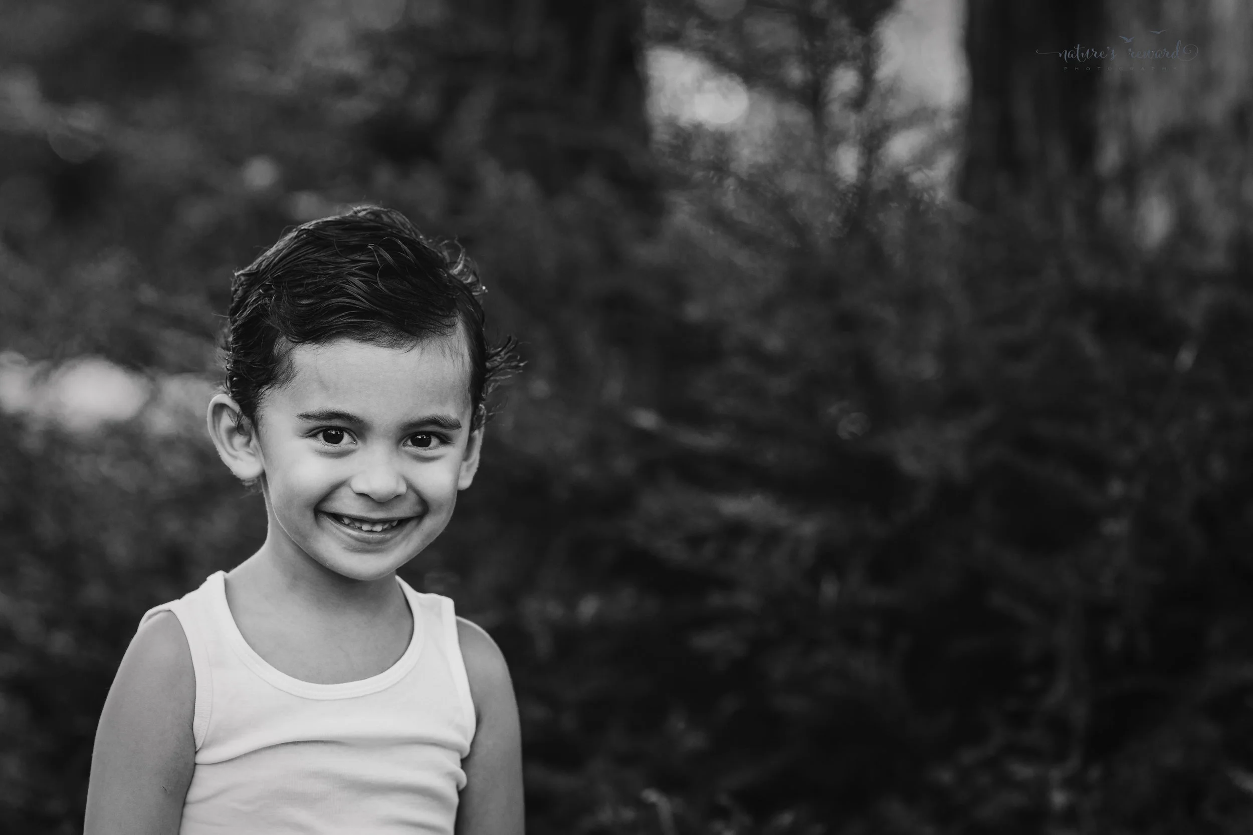 Close up black and white portrait of a young boy by Nature's Reward Photography