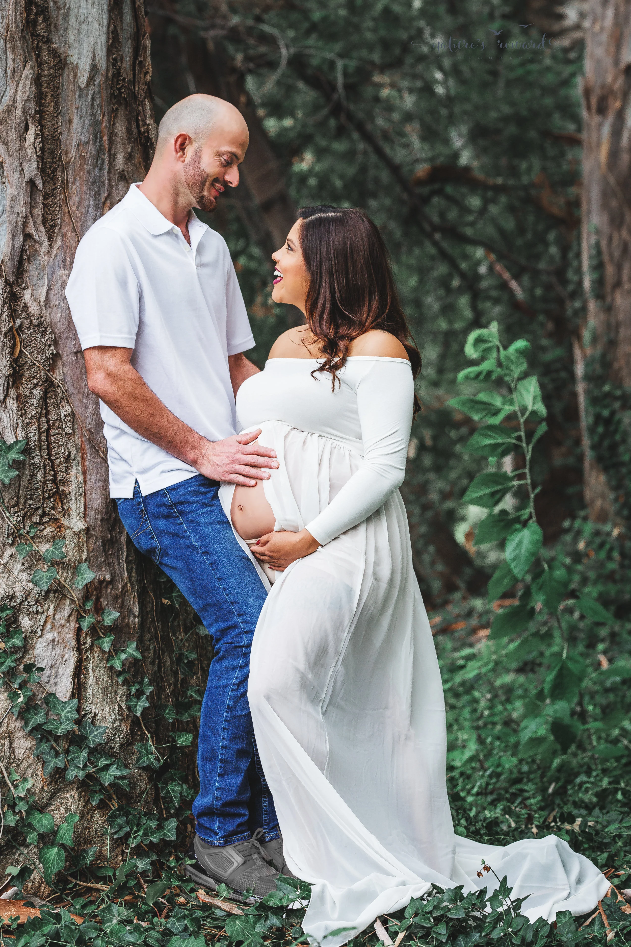 Beautiful couple celebrating the upcoming birth of their 3rd son in this maternity session portrait in white by Nature’s Reward Photography.