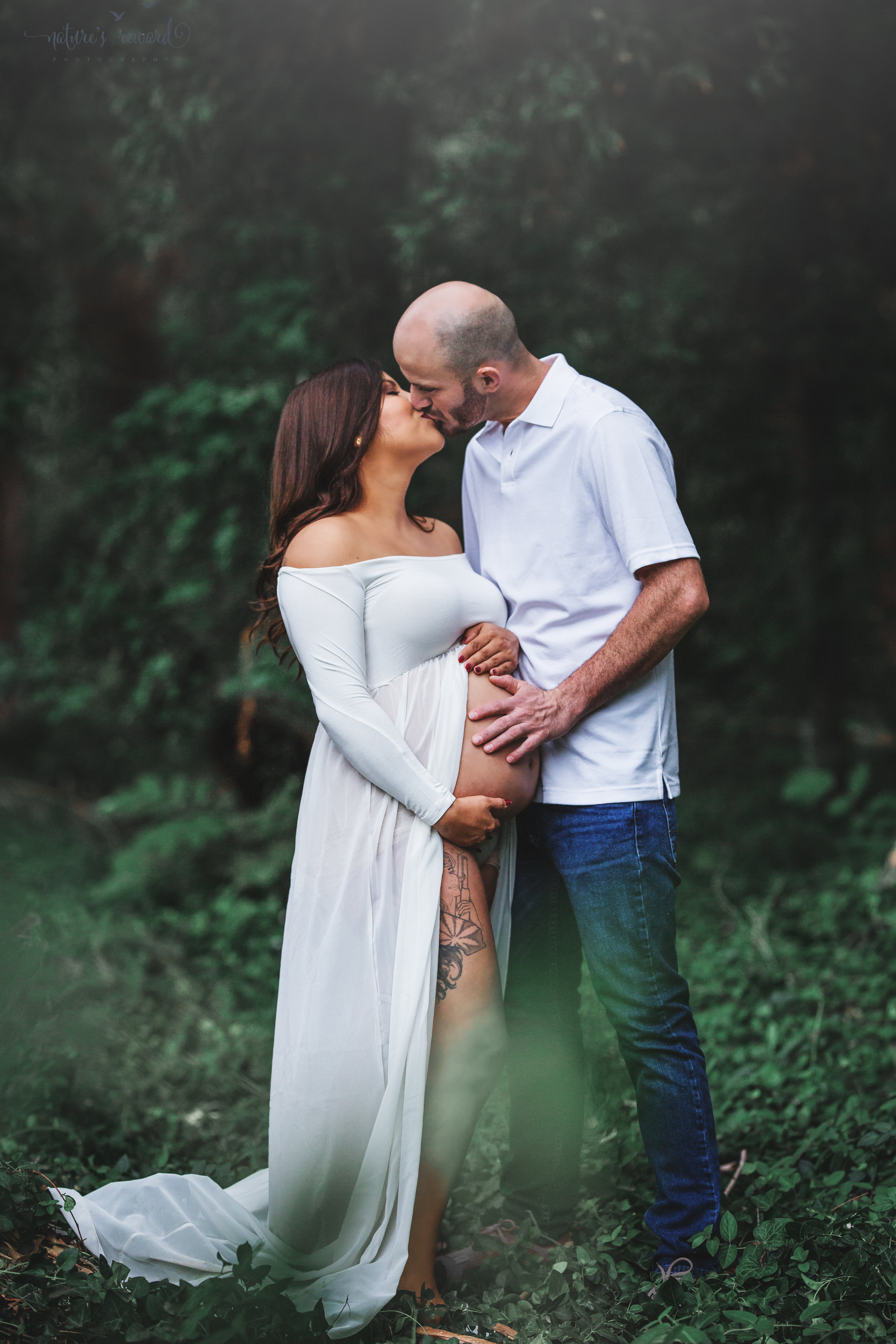 Beautiful couple celebrating the upcoming birth of their 3rd son in this maternity session portrait in white by Nature’s Reward Photography.