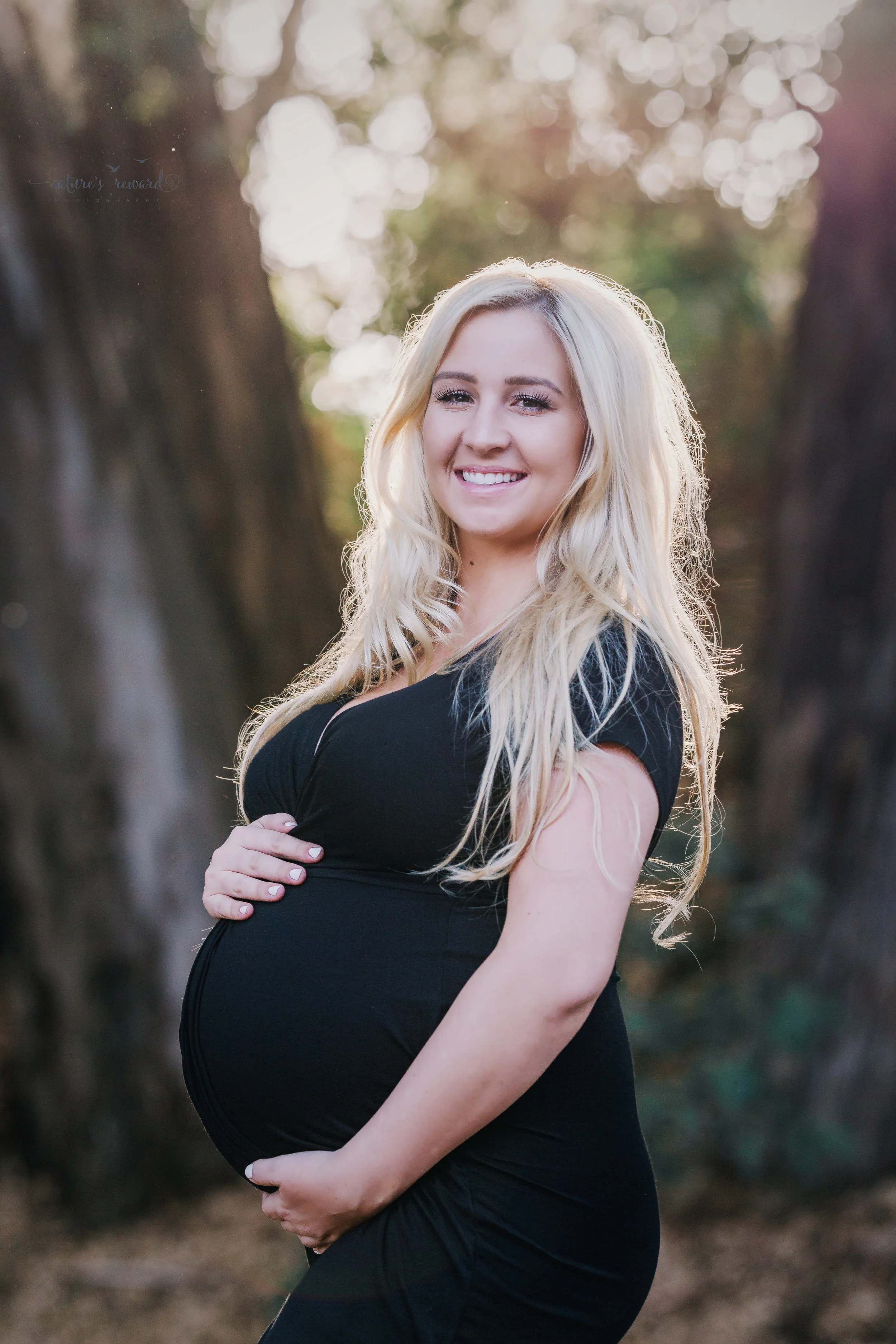 Beautiful expecting mother in a black gown in this portrait by Nature’s Reward Photography