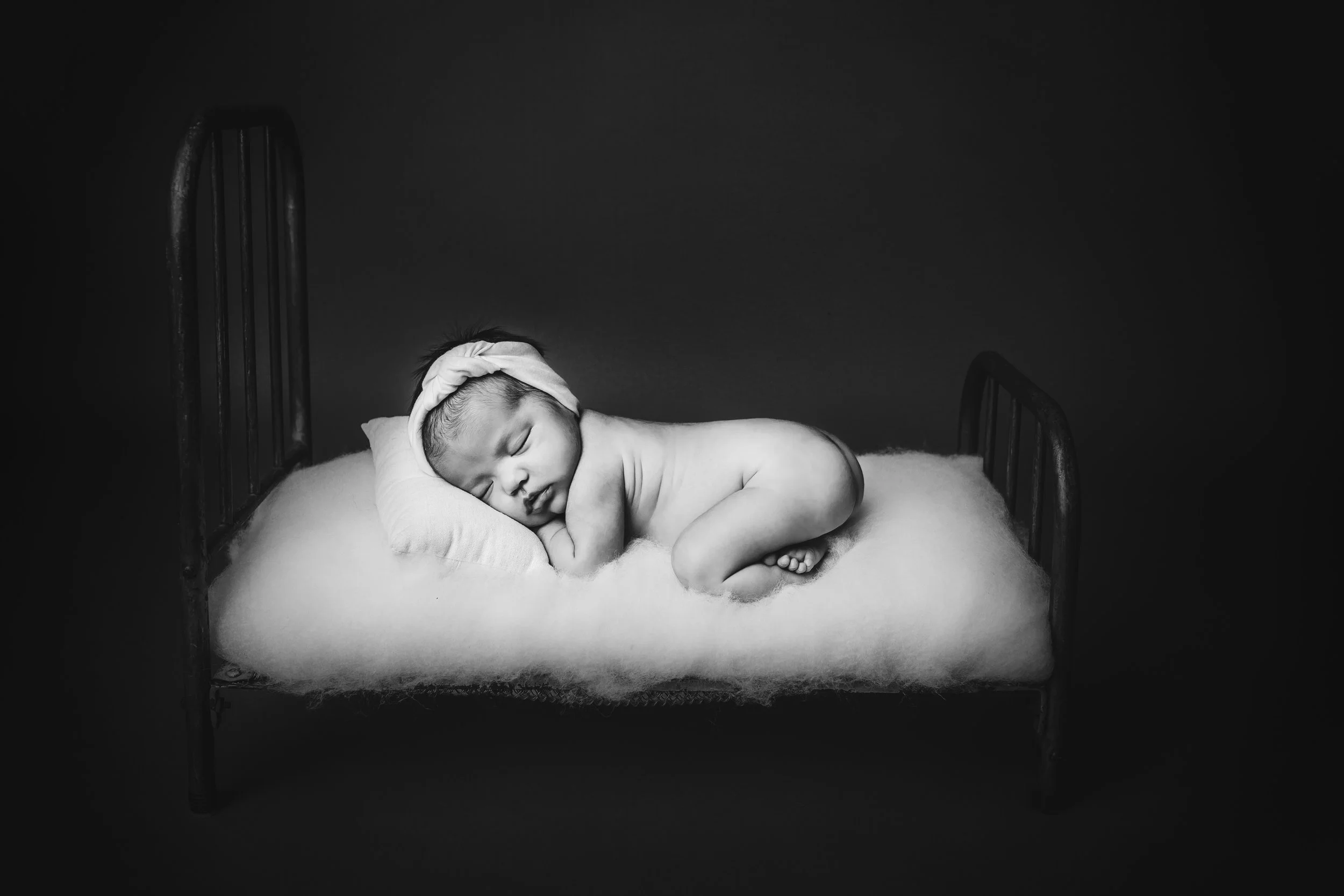 Newborn Baby girl in bum up pose- a black and white portrait by Nature’s Reward Photography.