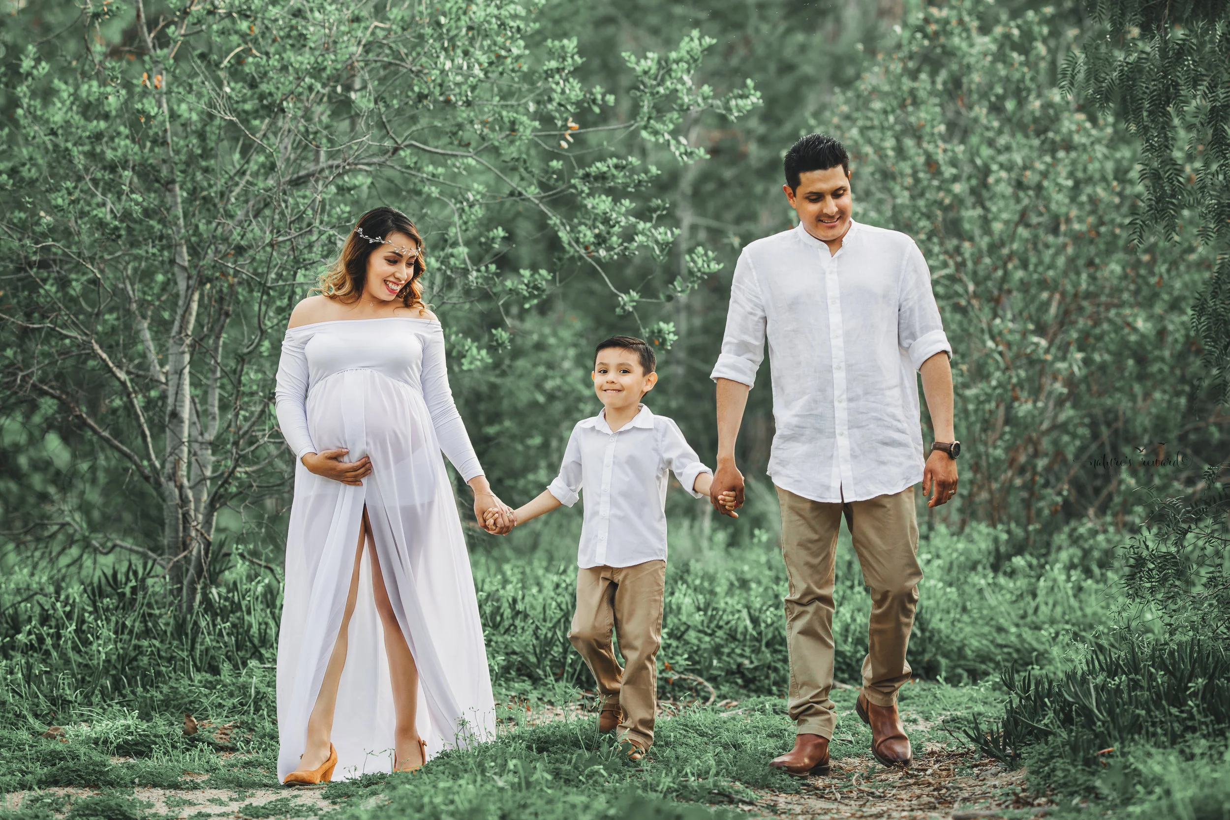 Expecting mother to be in white open front gown in this family maternity session portrait by Nature’s Reward Photography