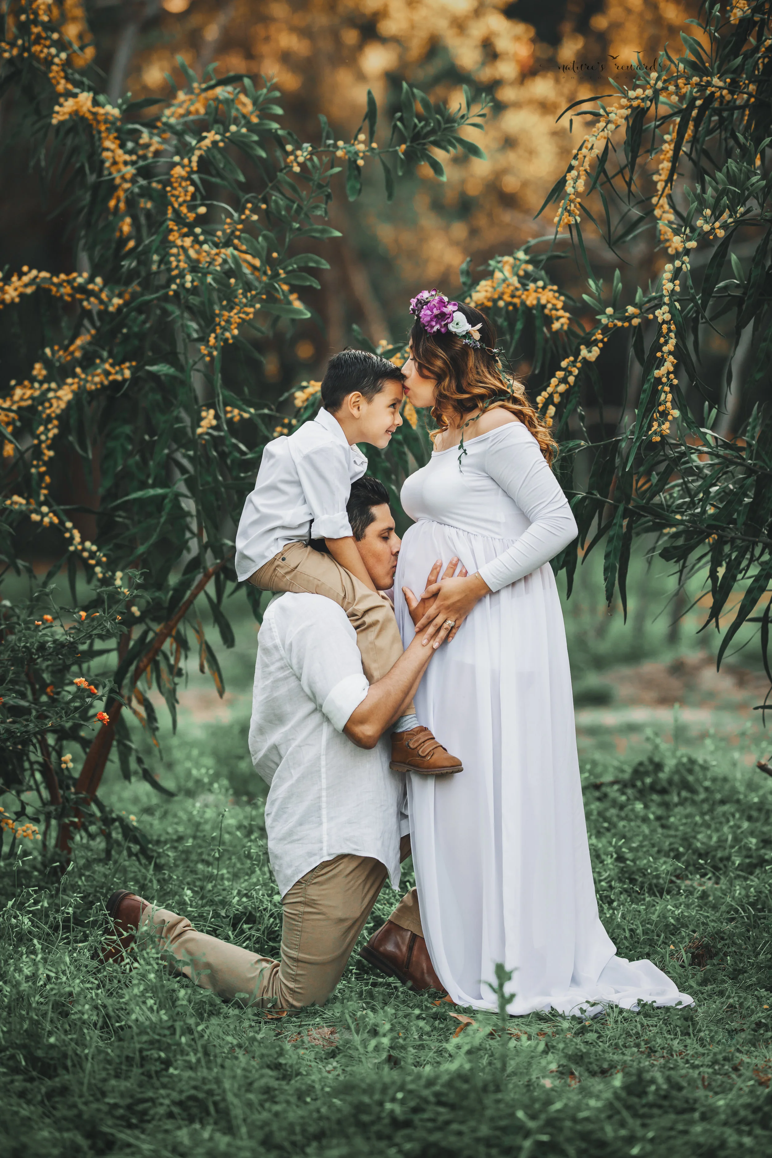 Expecting mother to be in white open front gown in this family maternity session portrait by Nature’s Reward Photography