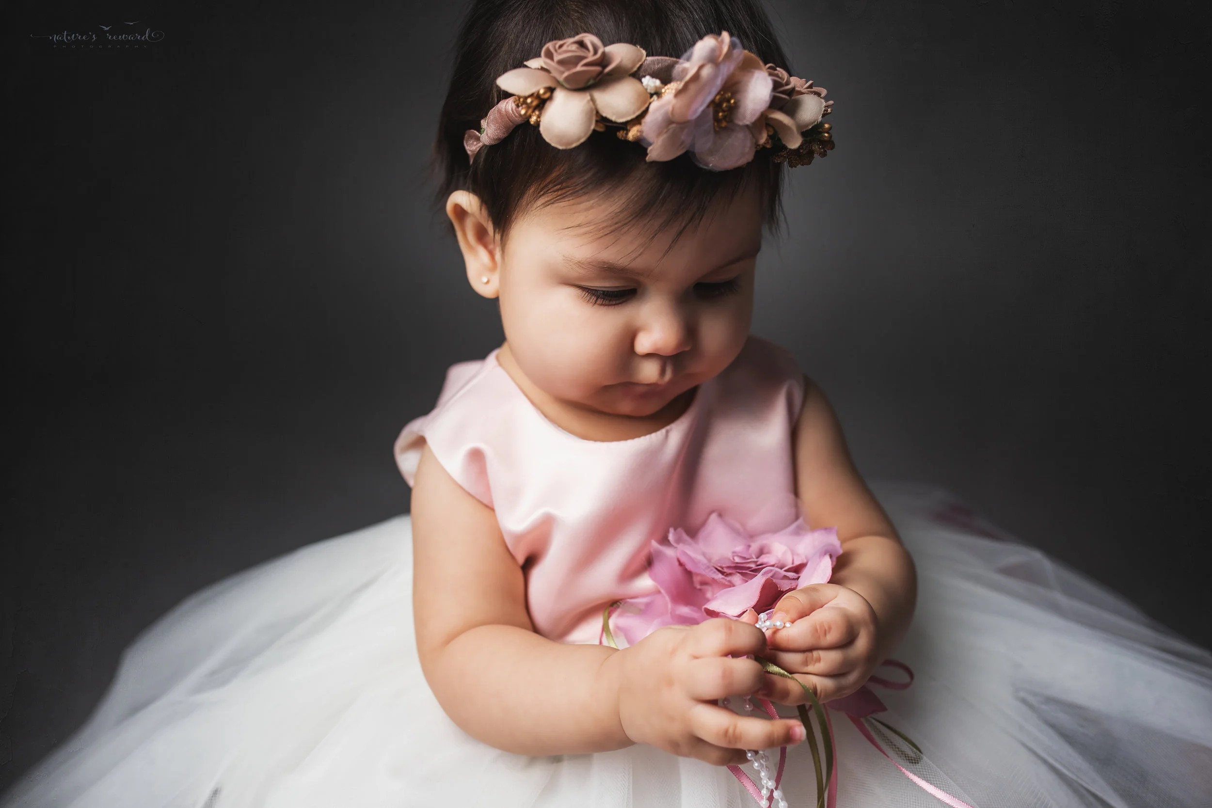 First year in a beautiful dress and flower crown, a portrait by Nature’s Reward Photography