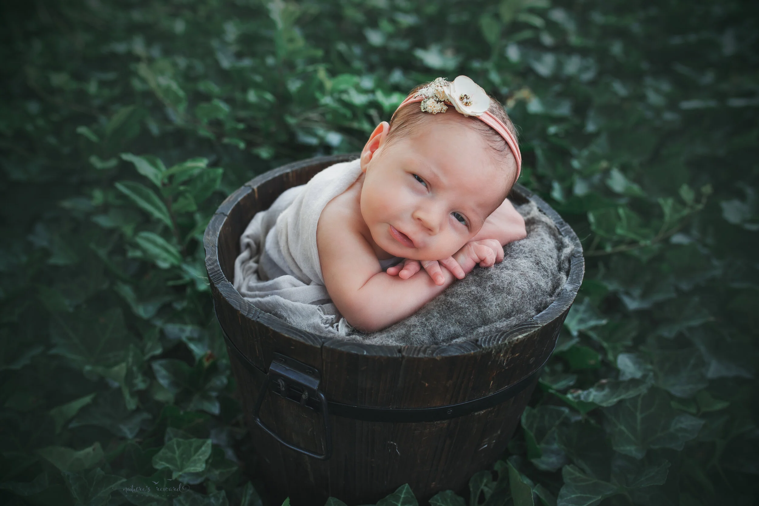 Newborn Baby girl in garden portrait by Nature’s Reward Photography