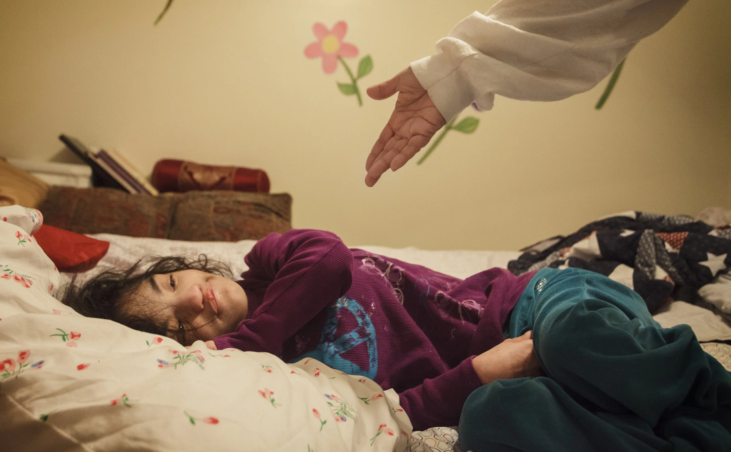  Mariana Perfetto reaches to lift her daughter Becca, 17, from bed to get her ready for school. Becca was born with Wolf-Hirschhorn syndrome, leaving her unable to walk, speak, eat or develop normally. 