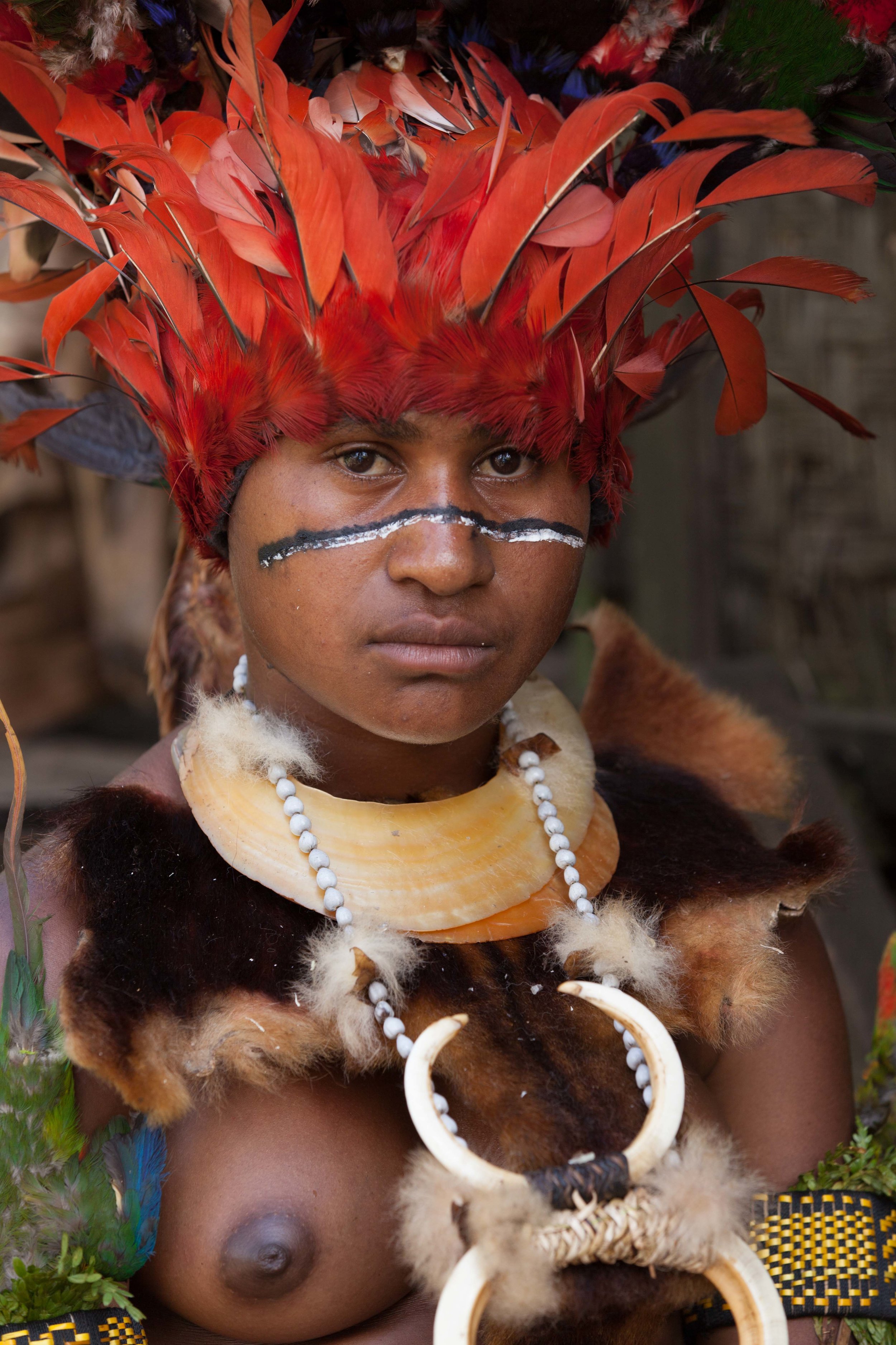 Member of a bridal party wearing a kina shell necklaces. Bollen village, Chimbu province