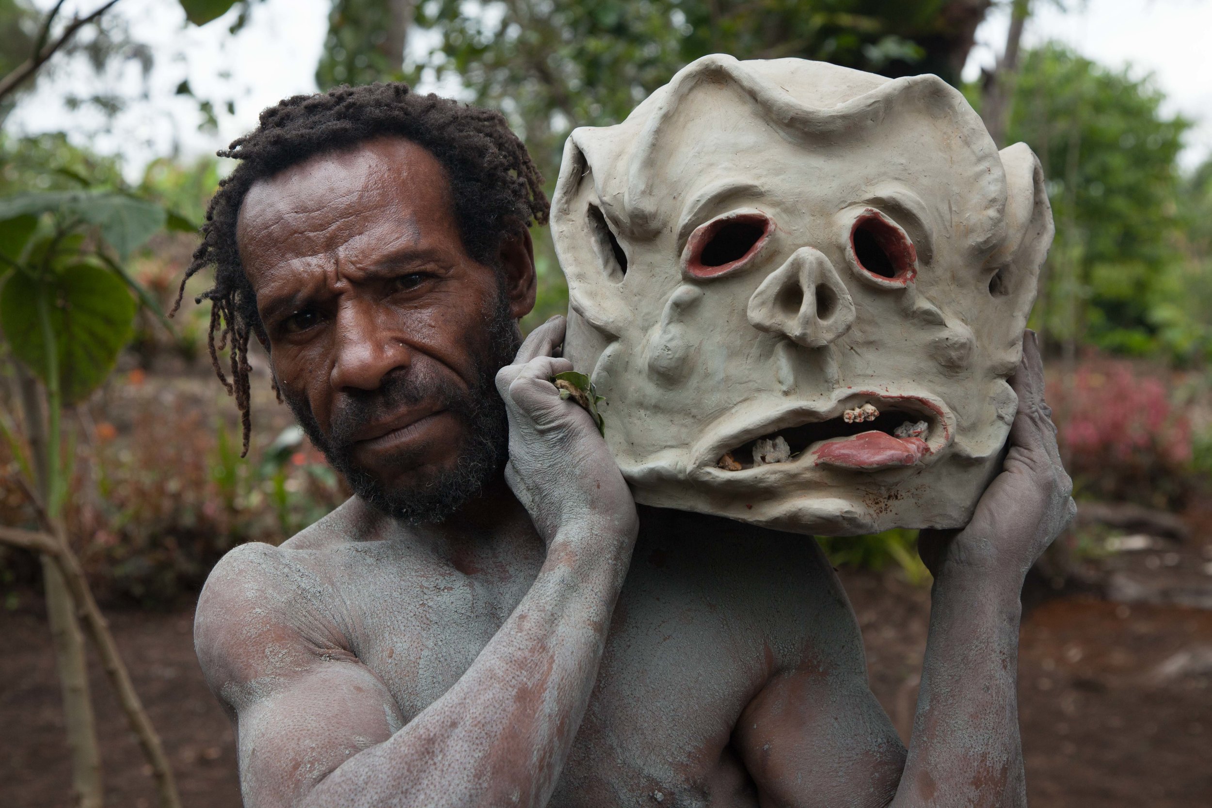 One of the famous Asaro Mudmen shows off his clay mask. Eastern Highland province