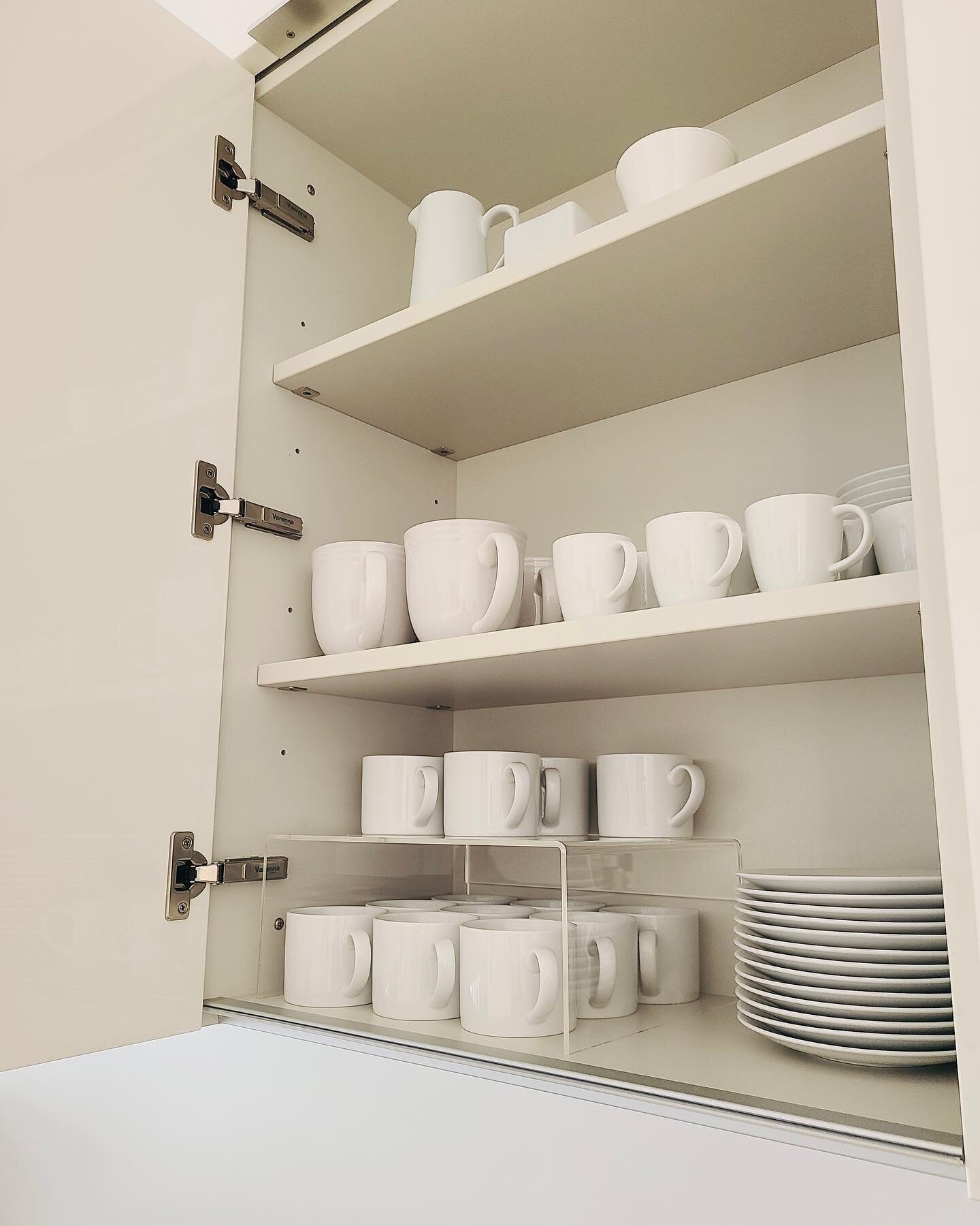 Simplify. ☕️ If your mix of colors and styles is causing overwhelm every time you reach for a mug or glass, it's time to start fresh with new sets. A riser from @thecontainerstore doubles the usable space of the lower cabinet.✨