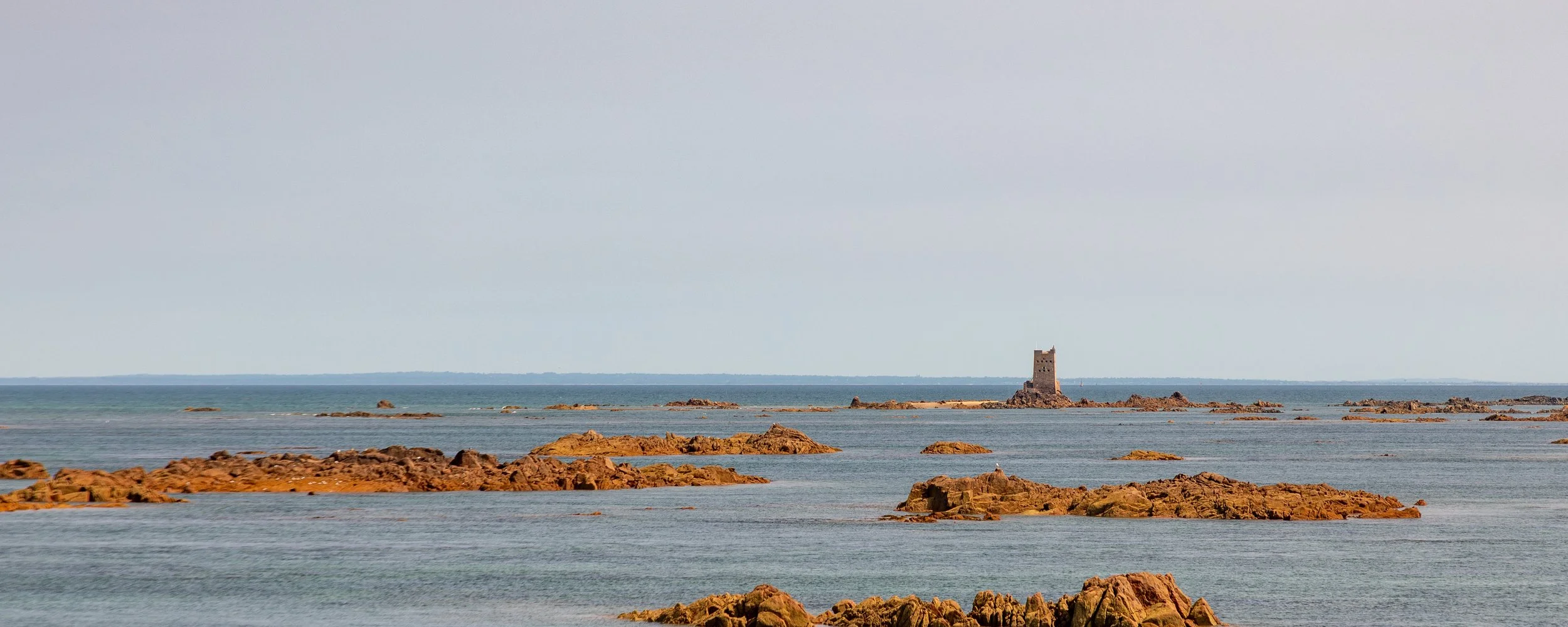  Small rocky formations and a remote fortification near the coast, as we look east towards France 