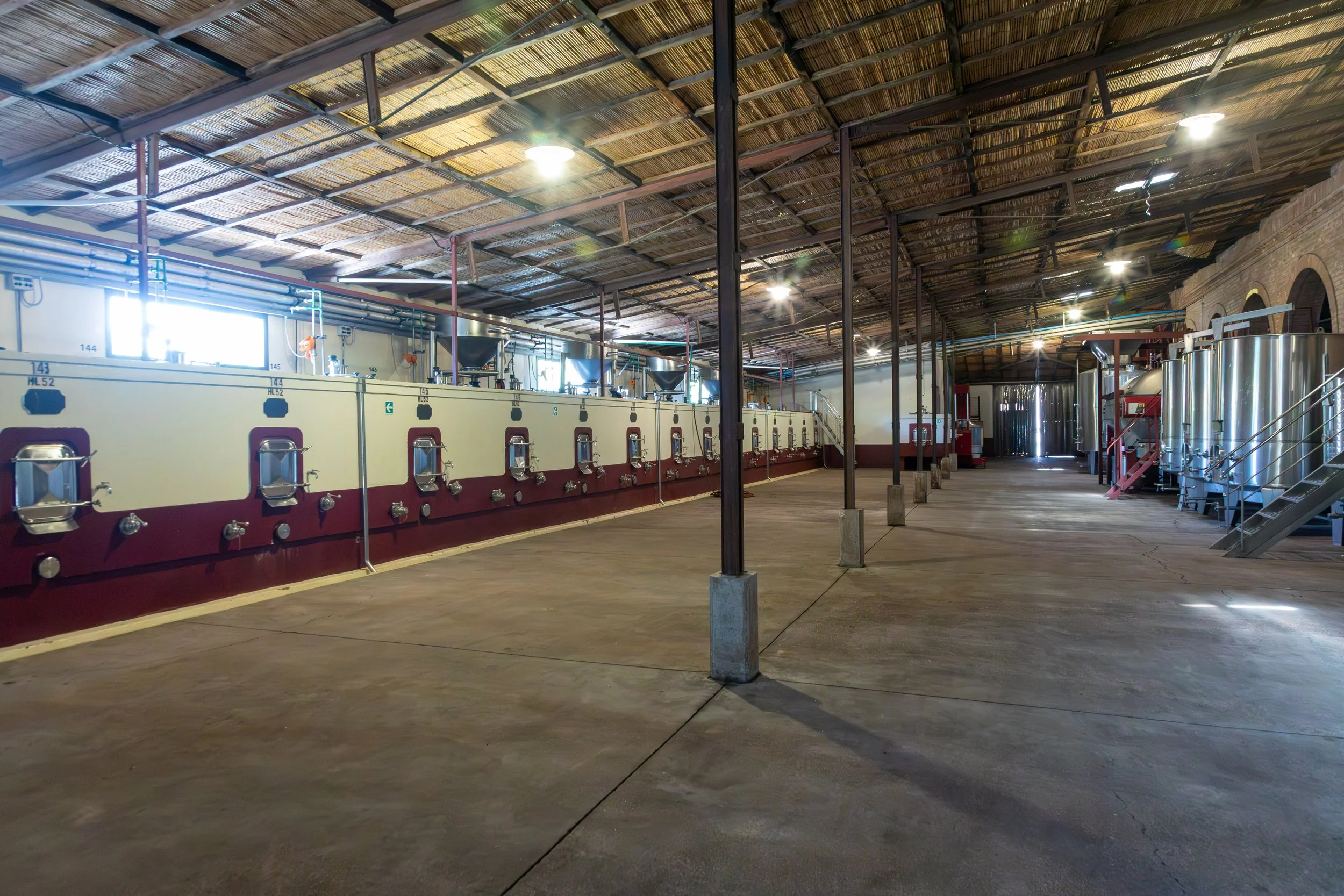  Historic metal tanks line the winery walls, with its high ceilings and natural ventilation keeping temperatures comfortable  