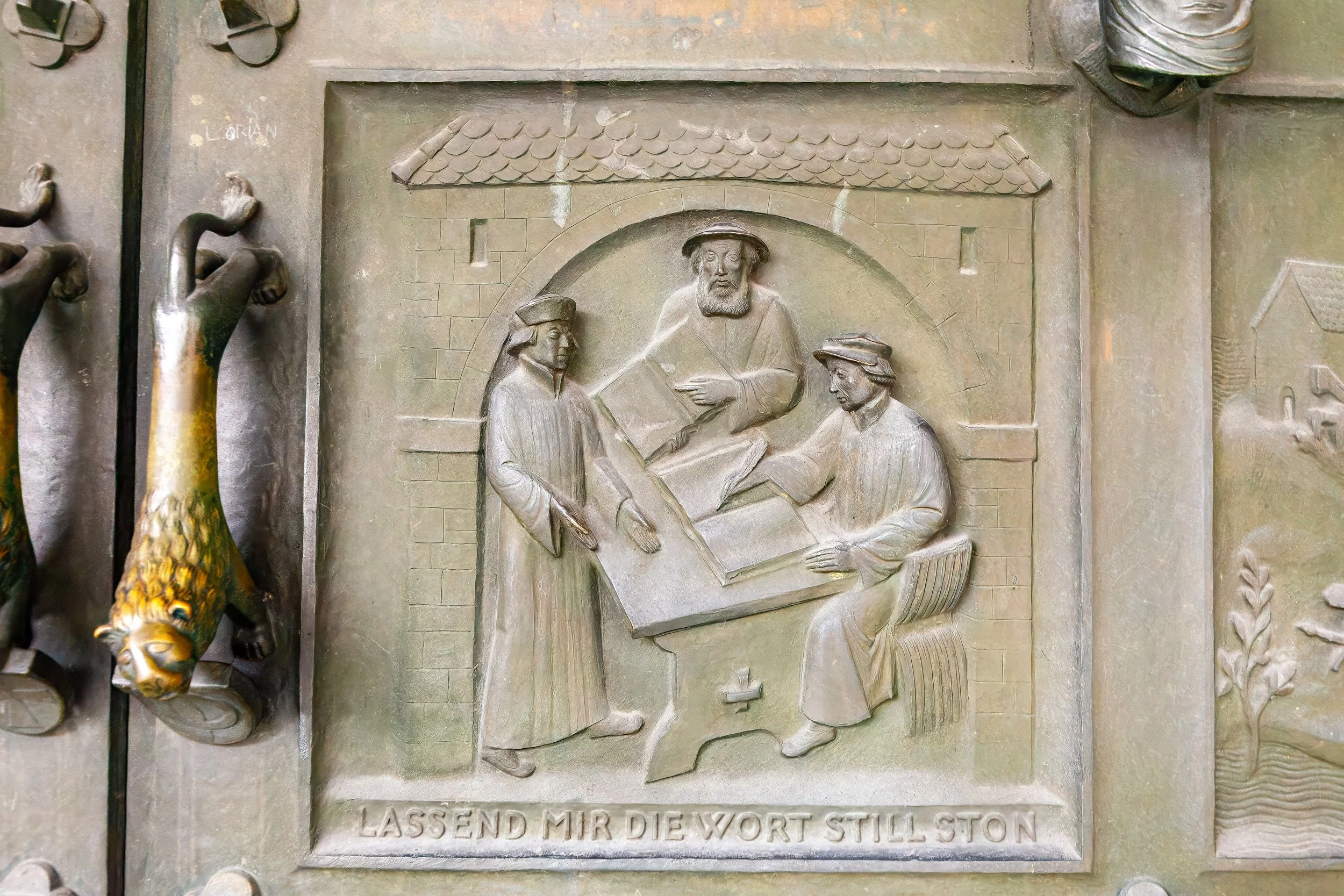  Relief panel on the bronze doors of the Grossmünster church depicts the work on the translation of the Bible 