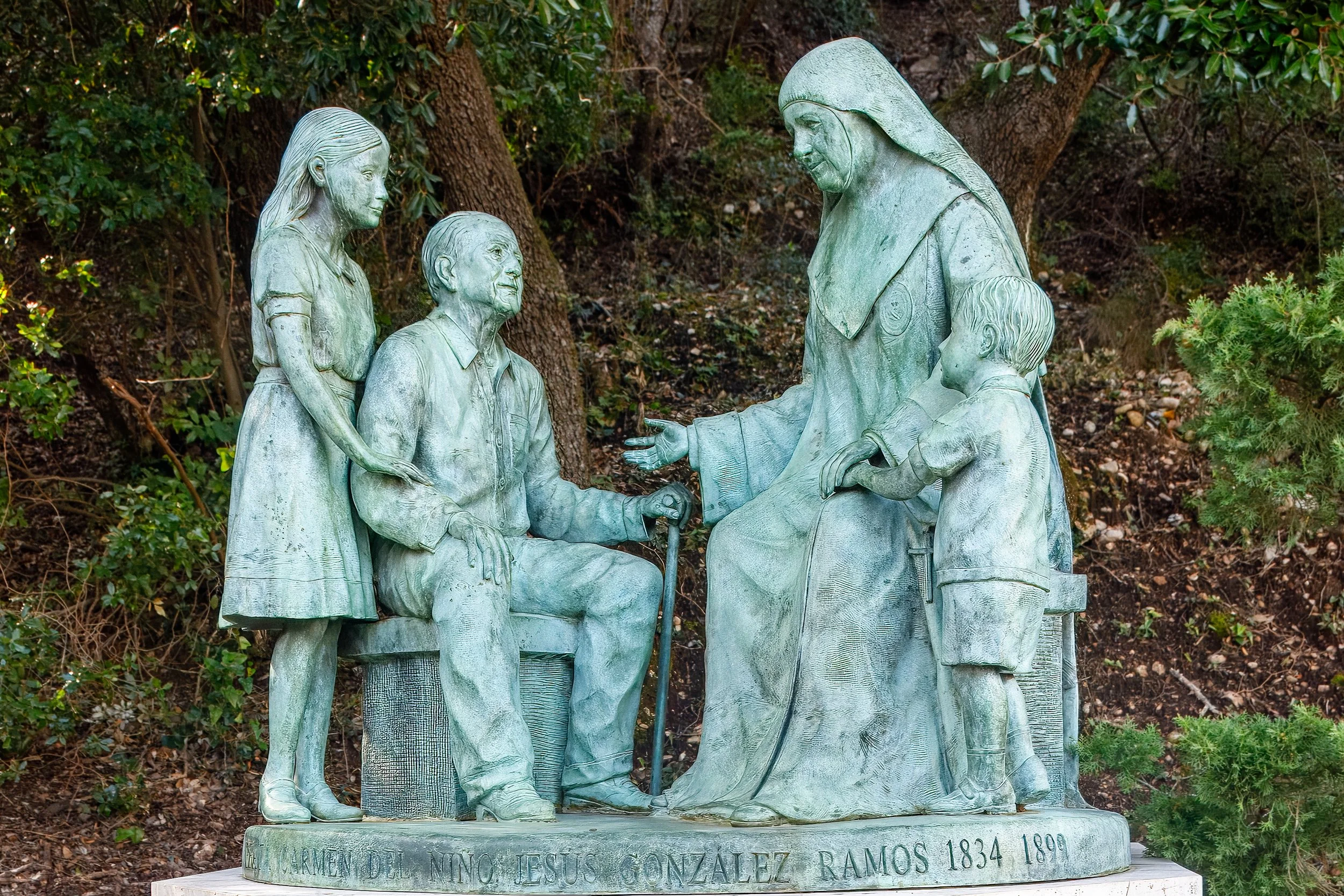 The  Madre Carmen  bronze sculpture depicts Mother Carmen interacting with an elderly man and two children 