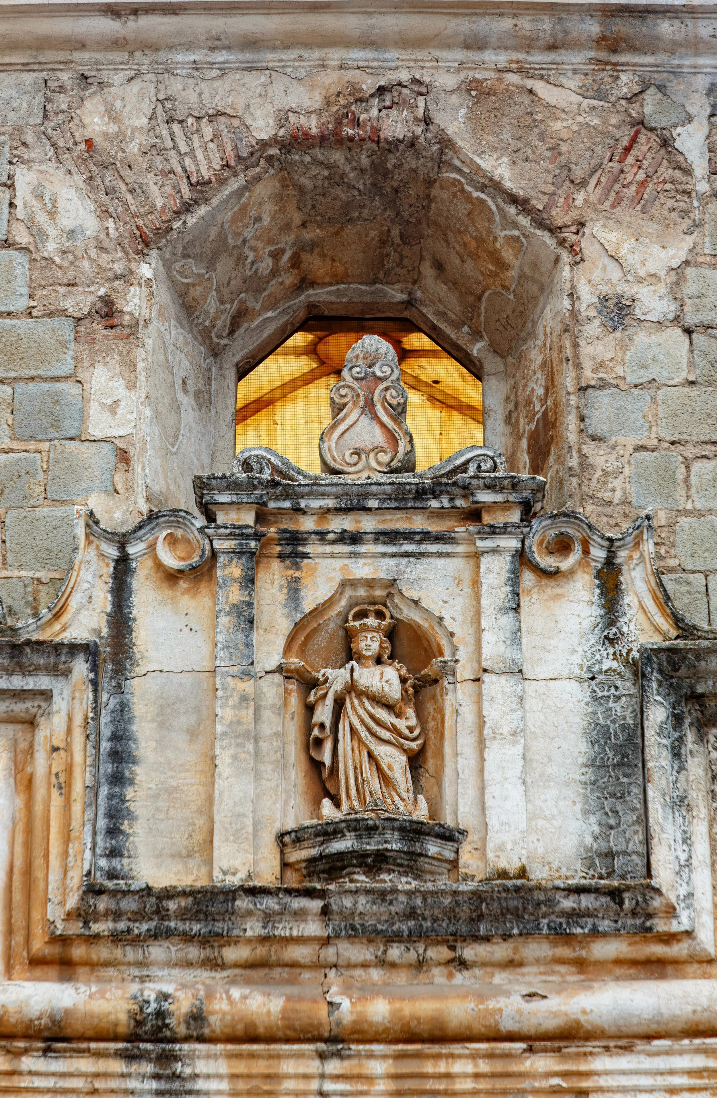  Stone facade featuring a religious statue at Iglesia and Convento de Santa Clara 