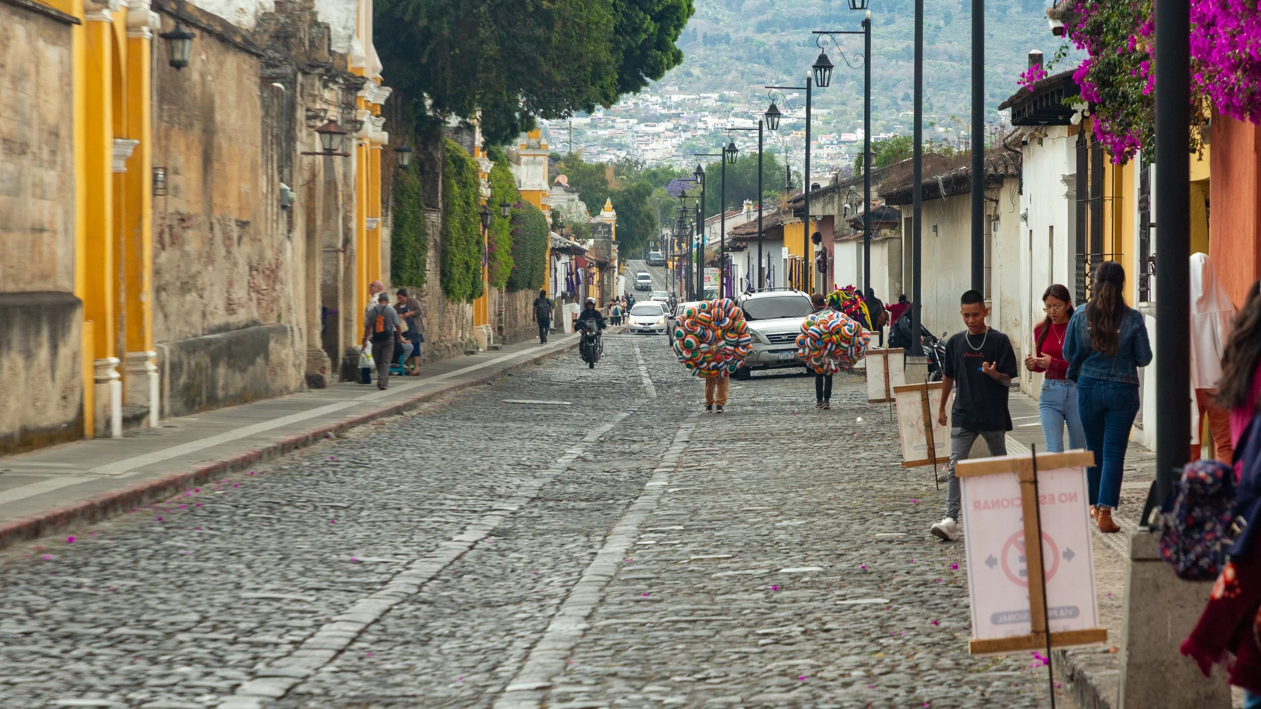  Looking further along Calle de los Pasos with street vendors carrying balls 