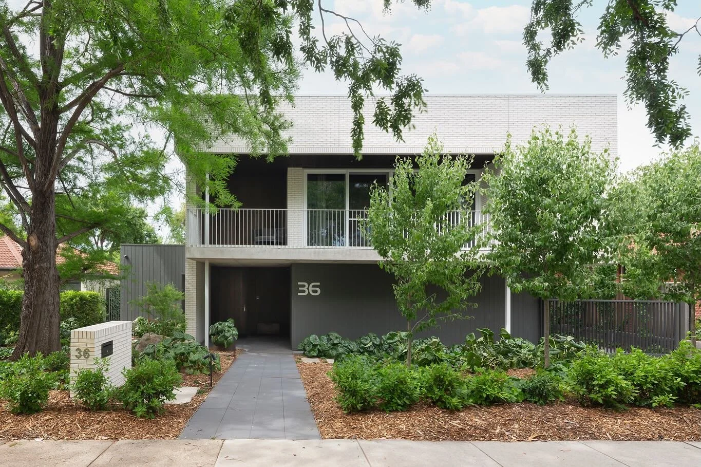 Reid House 🏠 
The leafy street frontage.

Architect: @de.rome.architects 
Builder: @35degreescanberra 
Photographer: @mr_adam_mcgrath 

#architecture #house #residentialarchitecture #cbr #concrete #exposedslab #brick #skinnybrick #terrace #metalbalu