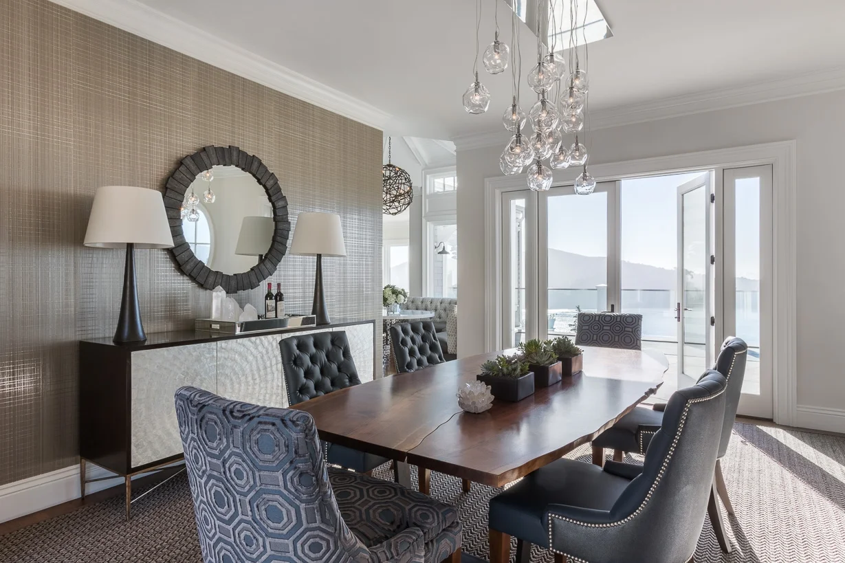 A wall covering by Phillip Jeffries and ceiling fixture by John Pomp lend the dining room a laid-back, coastal feel. The host chairs are covered in a Christopher Hyland print that echoes the octagonal pattern of the living room rug.
