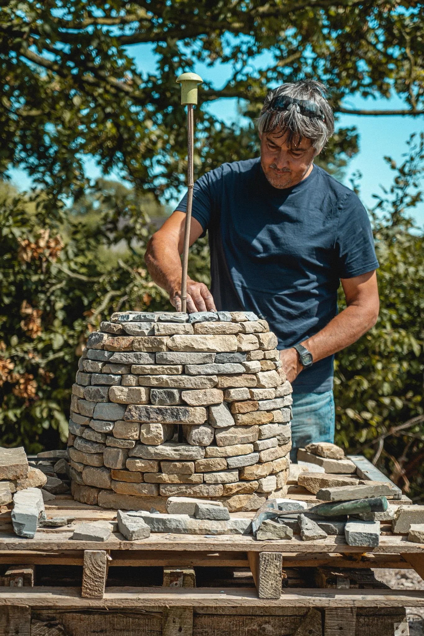 Paul Kendall building a stone beehive for a garden