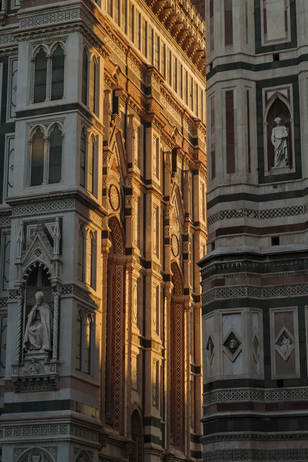 De een stukje voorgevel van de Cattedrale di Santa Maria del Fiore, met rechts de Giotto's Campanile en daartussen, de warme zonnestralen.