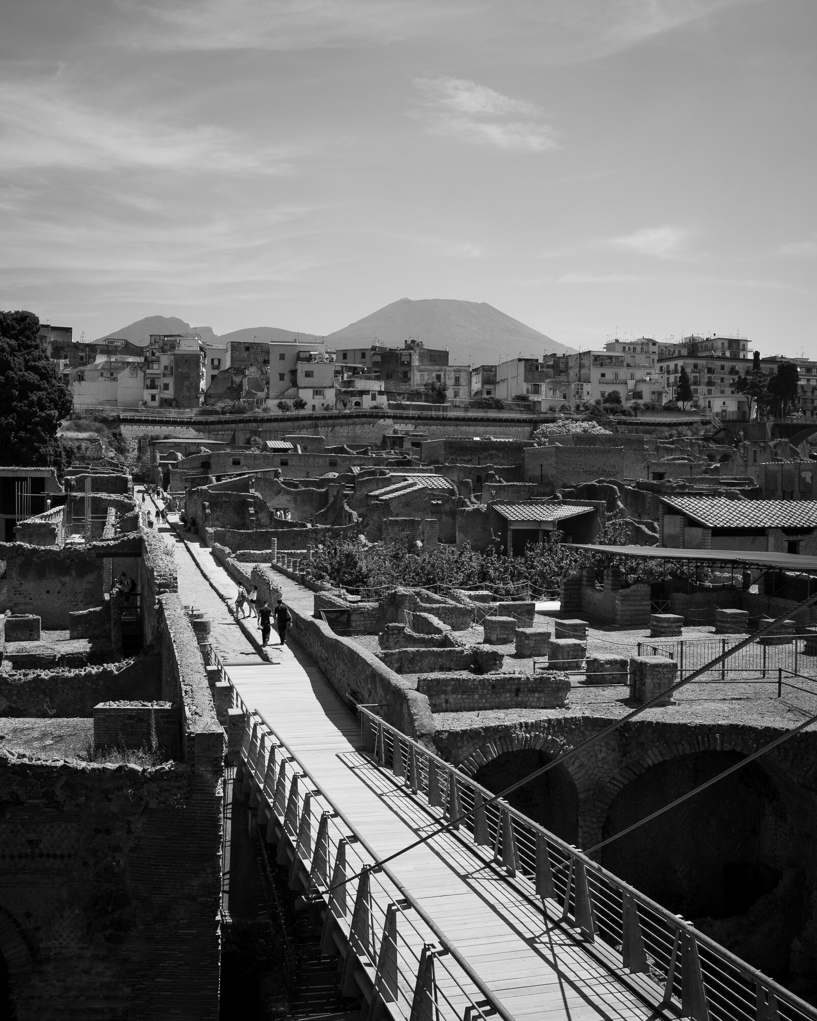 De ingang naar de opgraving. De havenwarenhuizen rechts onderin, de betonnen flats in het midden en op de achtergrond de Vesuvius.