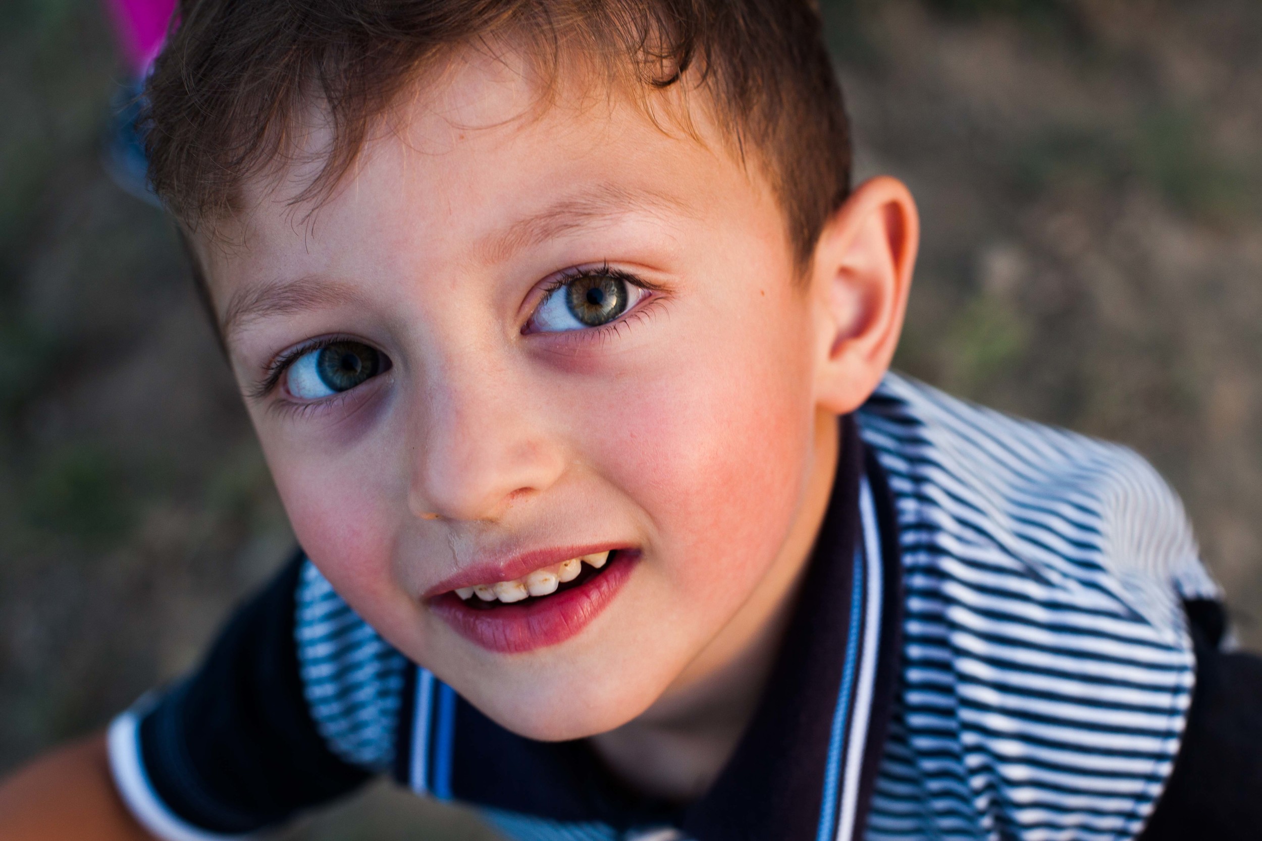 Hamltik, a young boy, stops for a portrait in between playing with his sister and his neighbor.