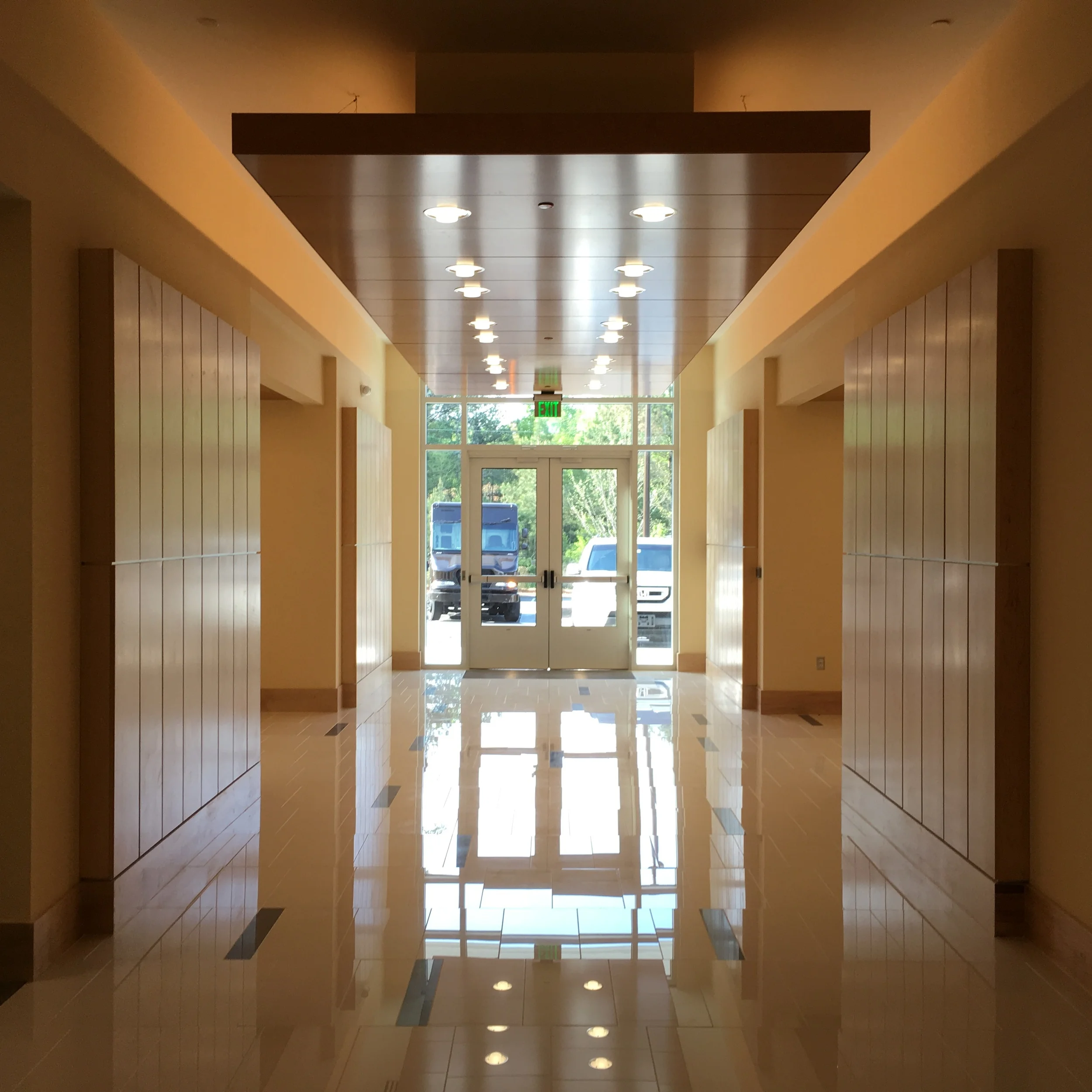   First Floor Lobby - bird's-eye maple veneer paneling with stainless reveals and polished limestone flooring.  