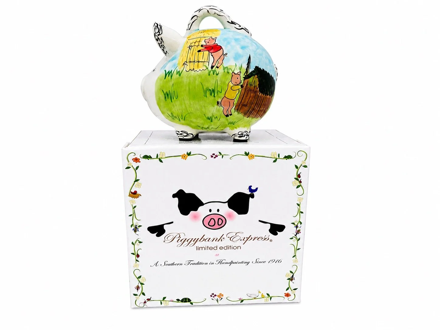 Handcrafted Three Little Pigs ceramic piggy bank featuring colorful storybook artwork, displayed with its decorative Piggybank Express limited-edition keepsake gift box